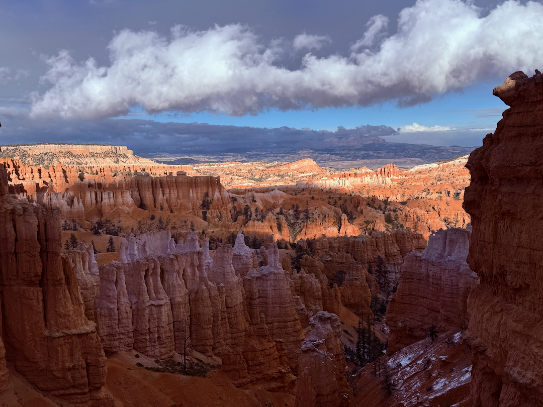 A stunning landscape of Bryce Canyon National Park showcases its unique red rock formations and hoodoos under a dramatic sky.