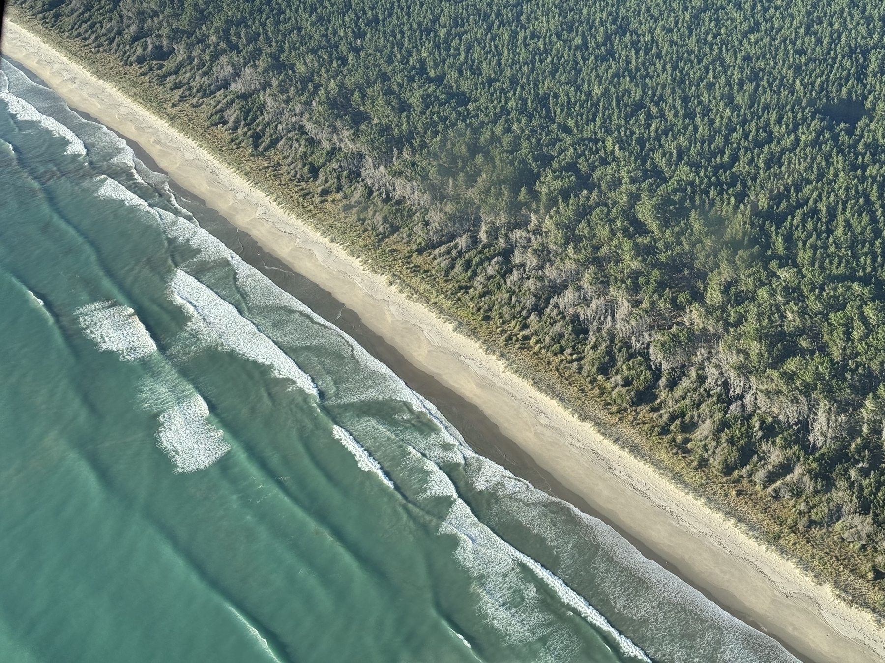 Aerial view of waves crashing against a sandy beach