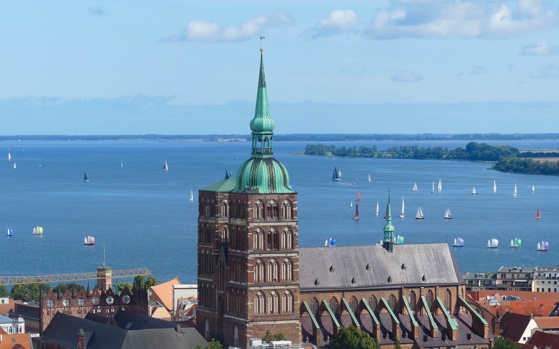 View from the tower of St Marien Kirche over Stralsund. Among other things, you can see the towers of the St Nikolai Kirche. On the water between Stralsund and Rüggen are many small sailboats