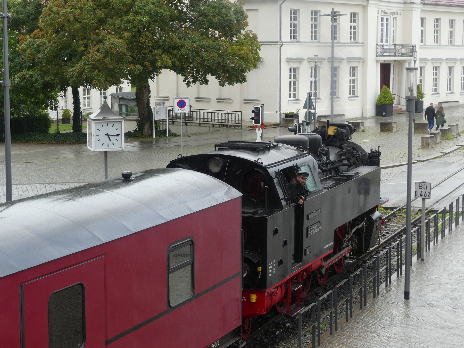 An old steam train in a rainy city center