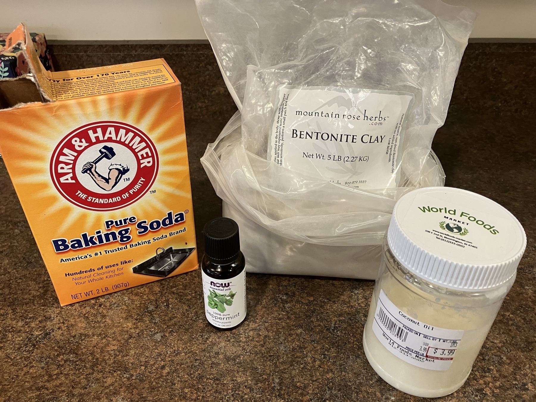 Containers of baking soda, bentonite clay, coconut oil, and peppermint oil. 