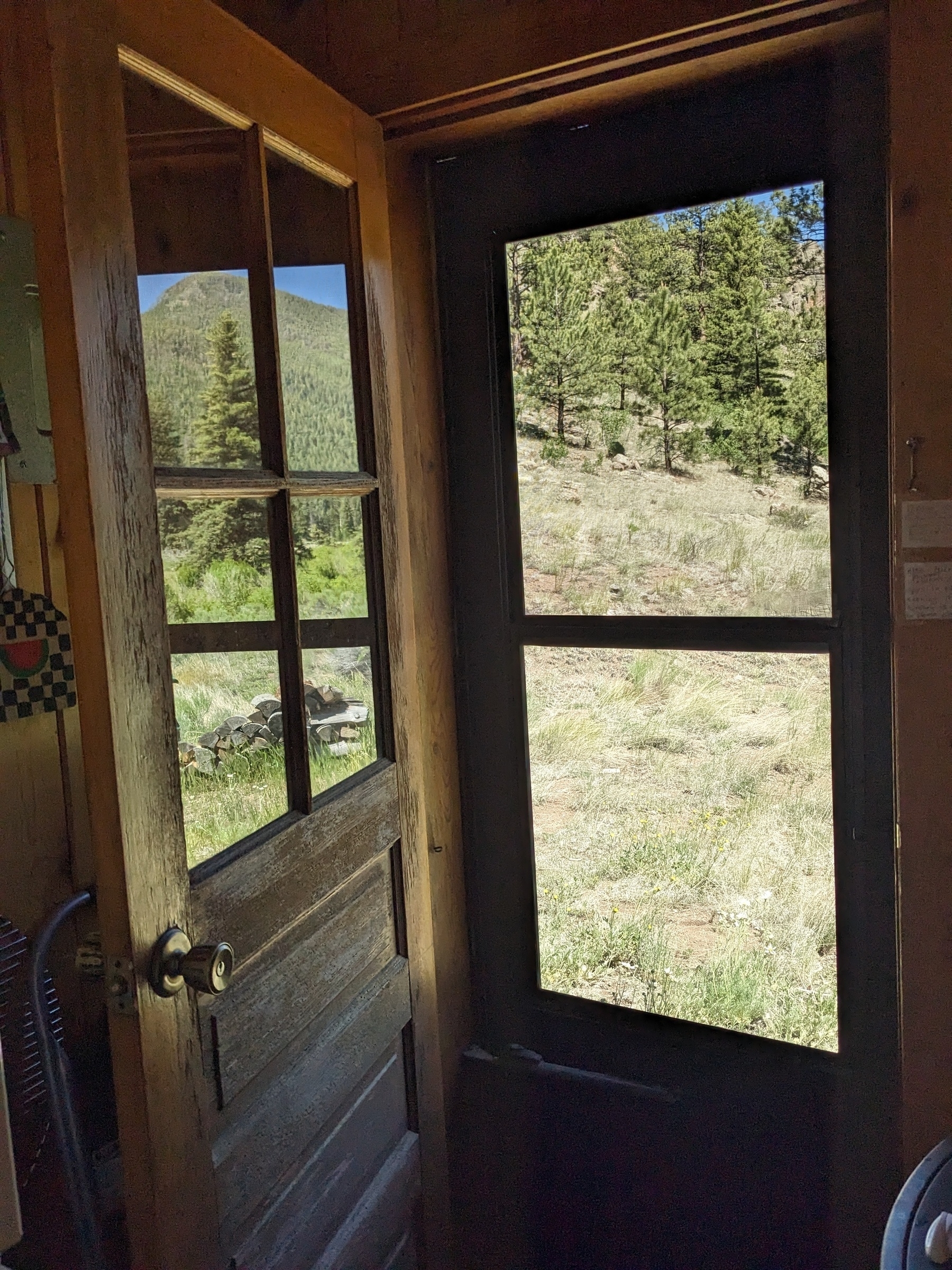 looking through an opened a weathered door in the mountains