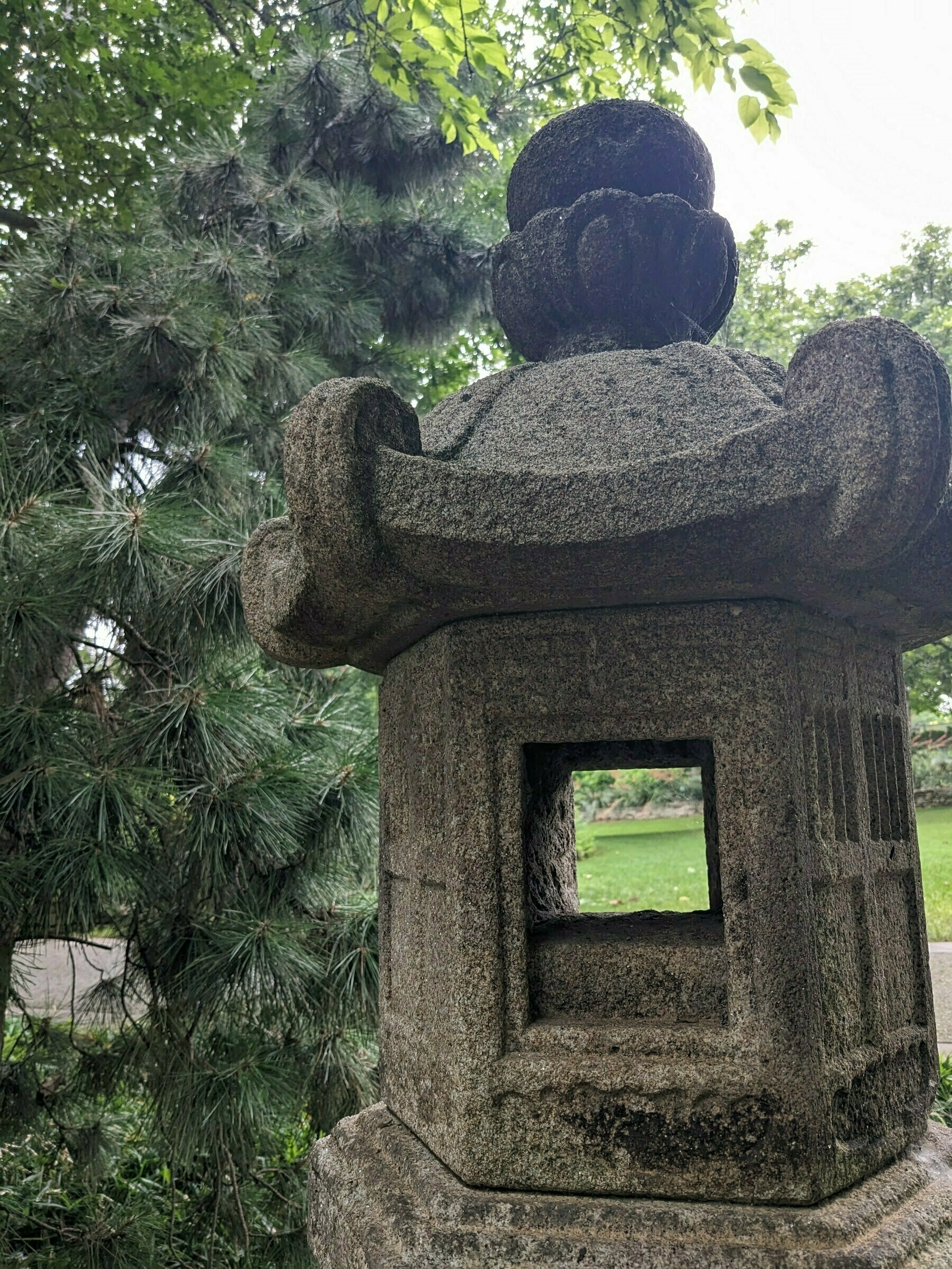 Looking through a Japanese stone lantern in a park