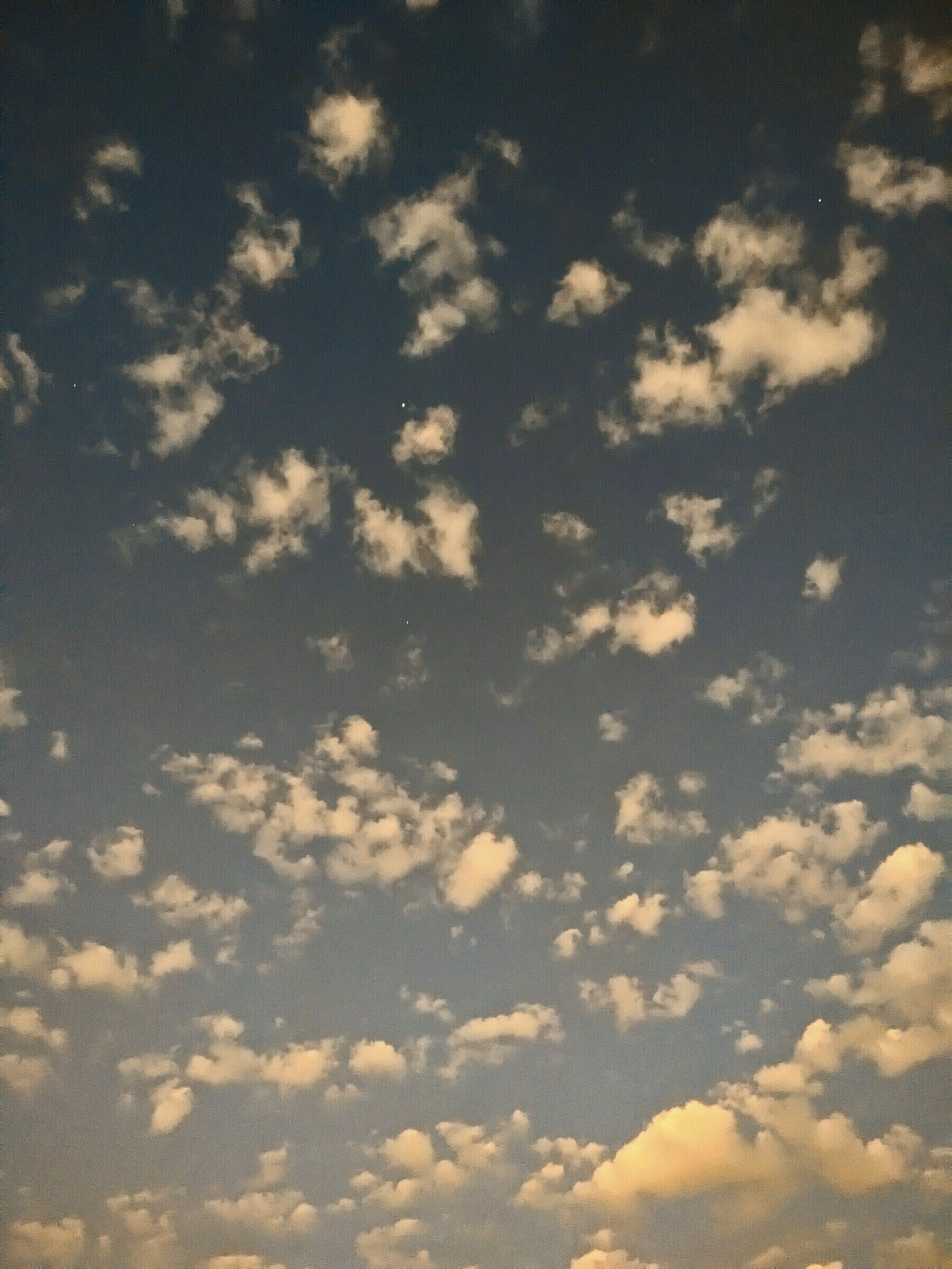 Auto-generated description: A sky filled with scattered clouds at dusk or dawn