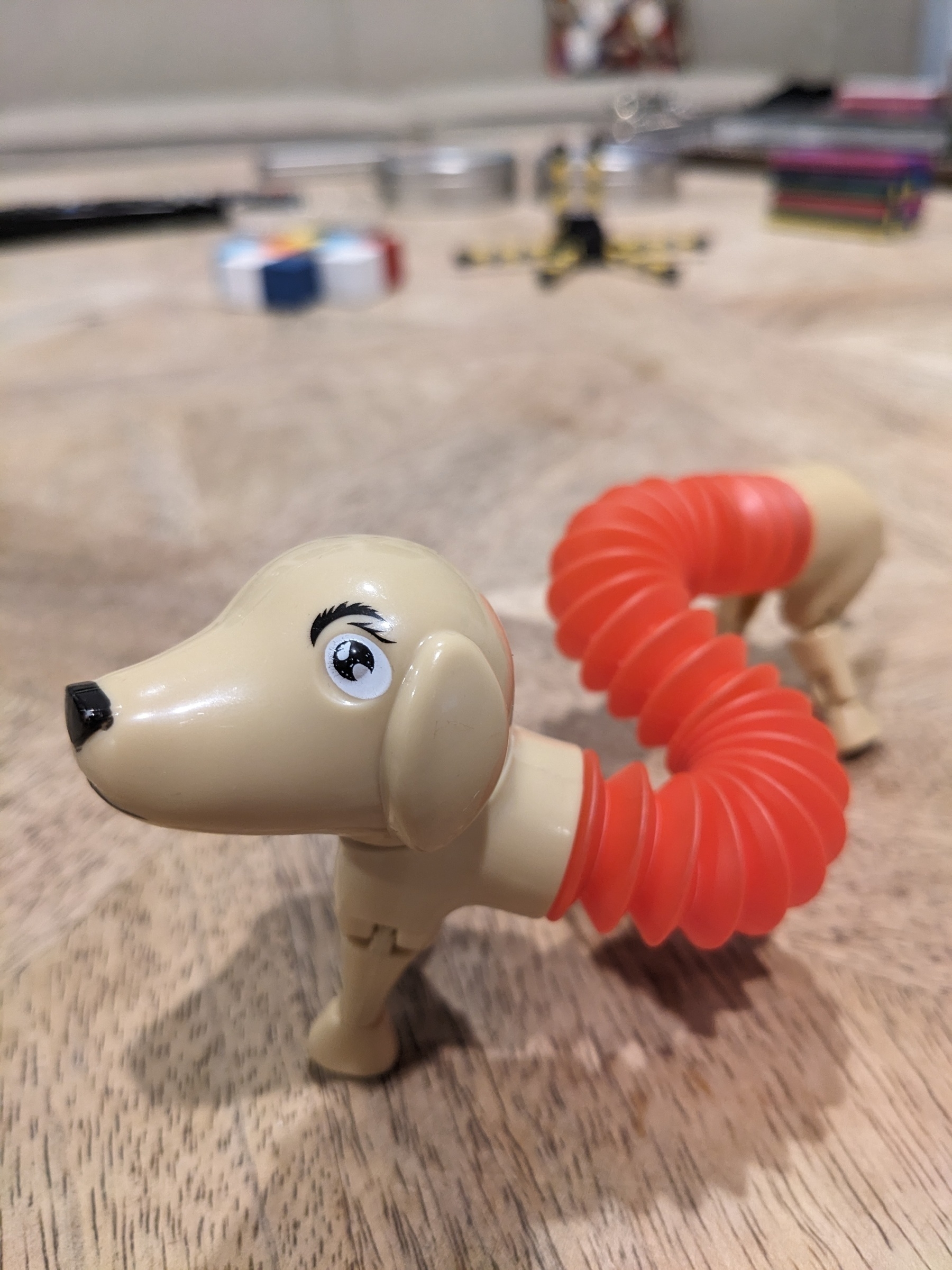 A toy shaped like a dog, with an accordion-fold torso allowing odd shapes 