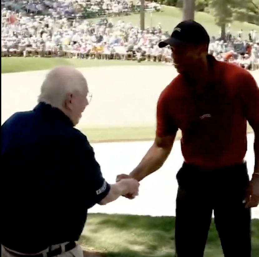 Tiger Woods and Verne Lundquist shake hands as Lundquist broadcasts his 40th and final Masters tournament