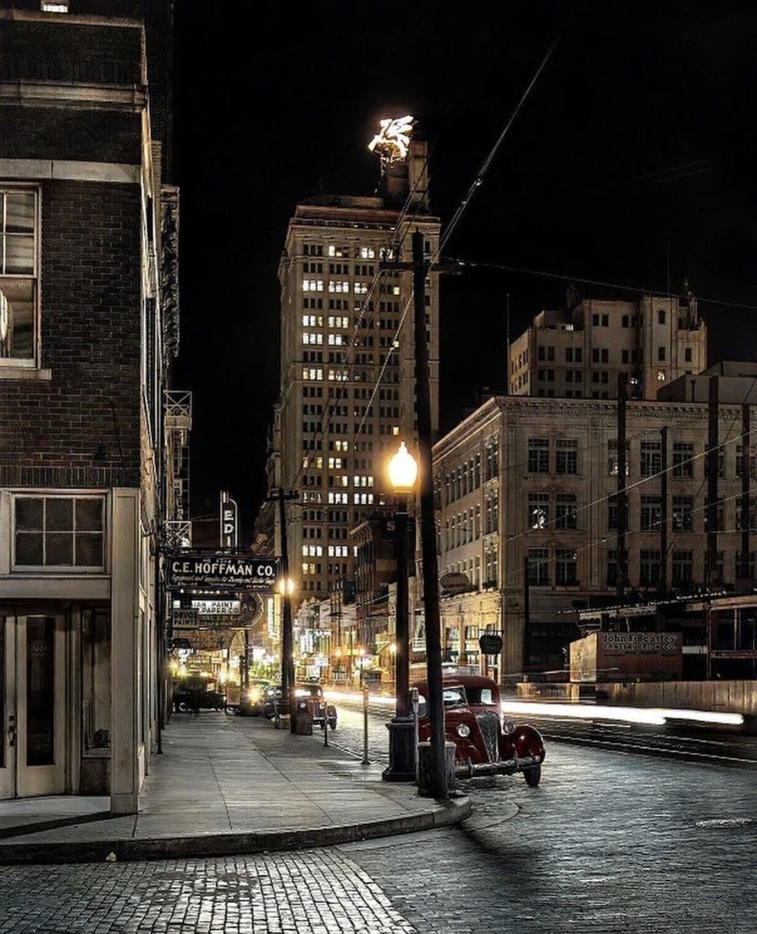 Vintage photo of Elm Street in Dallas at night, with neon Pegasus sign atop a building in the distance