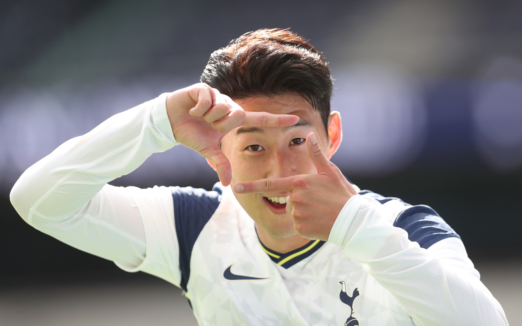 Son Heung-Min of Tottenham Hotspur Football Club smiling and making his signature goal-scoring gesture: making a view finder with his fingers in front of his face.