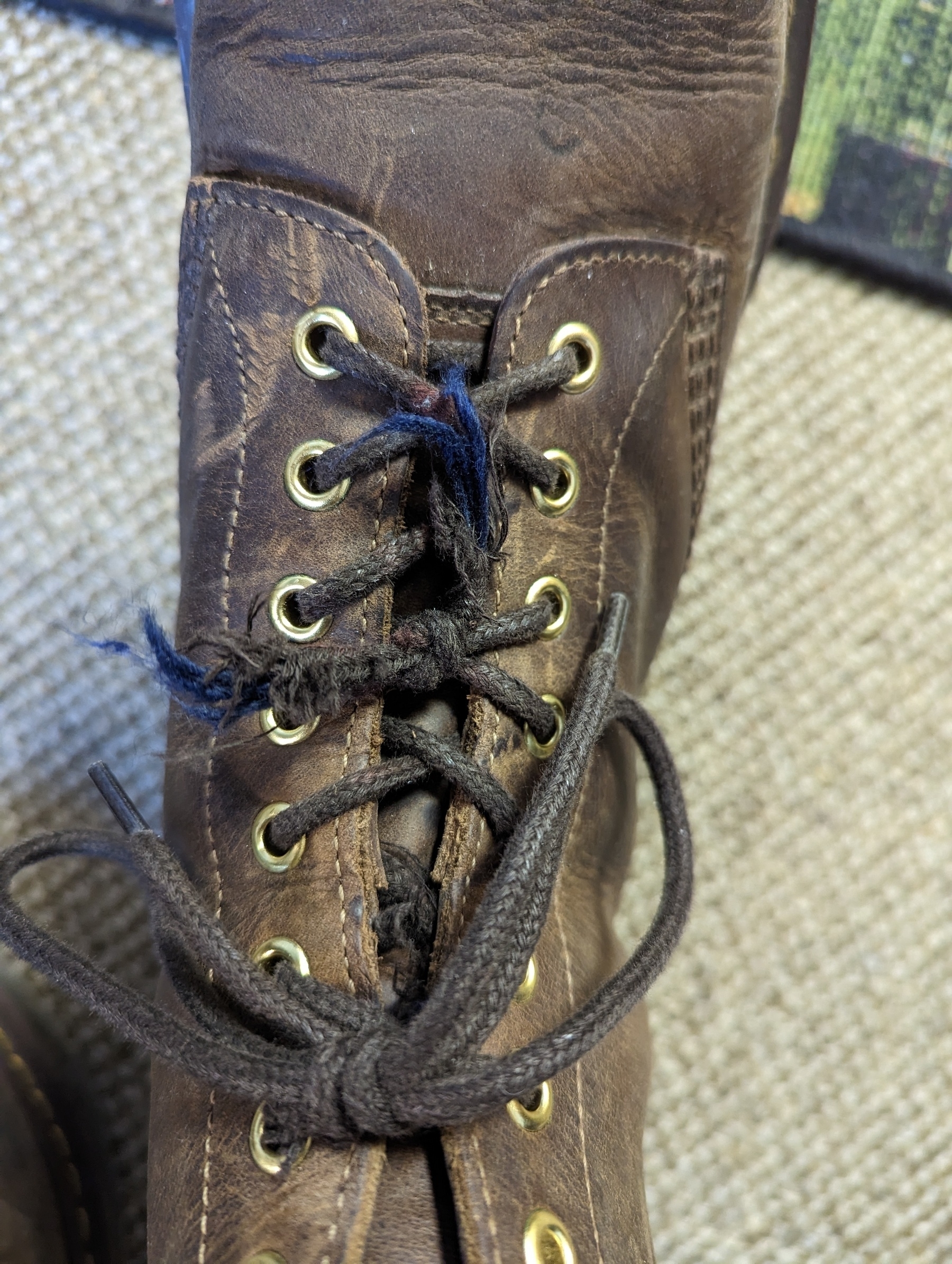 Broken boot laces secured with multiple knots