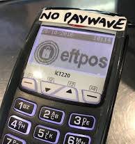An EFTPOS terminal with a hand-written sticker at the top of the unit