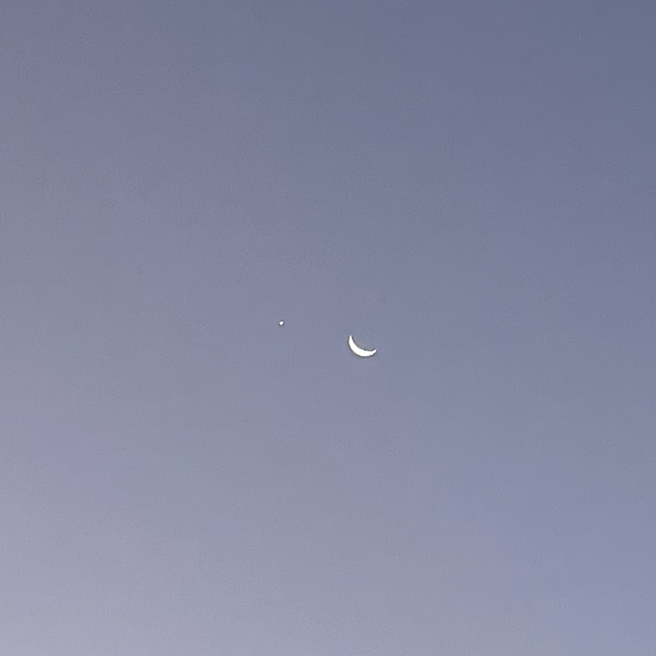 A cresent moon next to a very bright Venus, in a configuration that makes it look like two eyes, with one (the moon) winking.