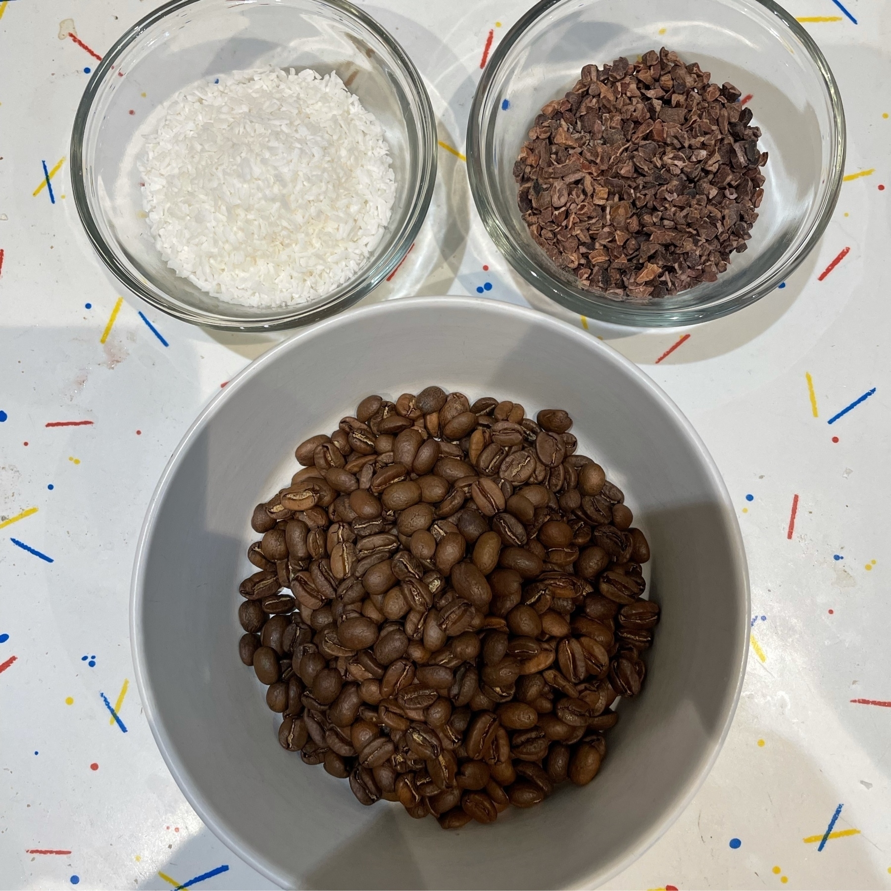 80 grams of coffee beans, 40 grams of cacao nibs and 40 grams of coconut all in seperate bowls. 