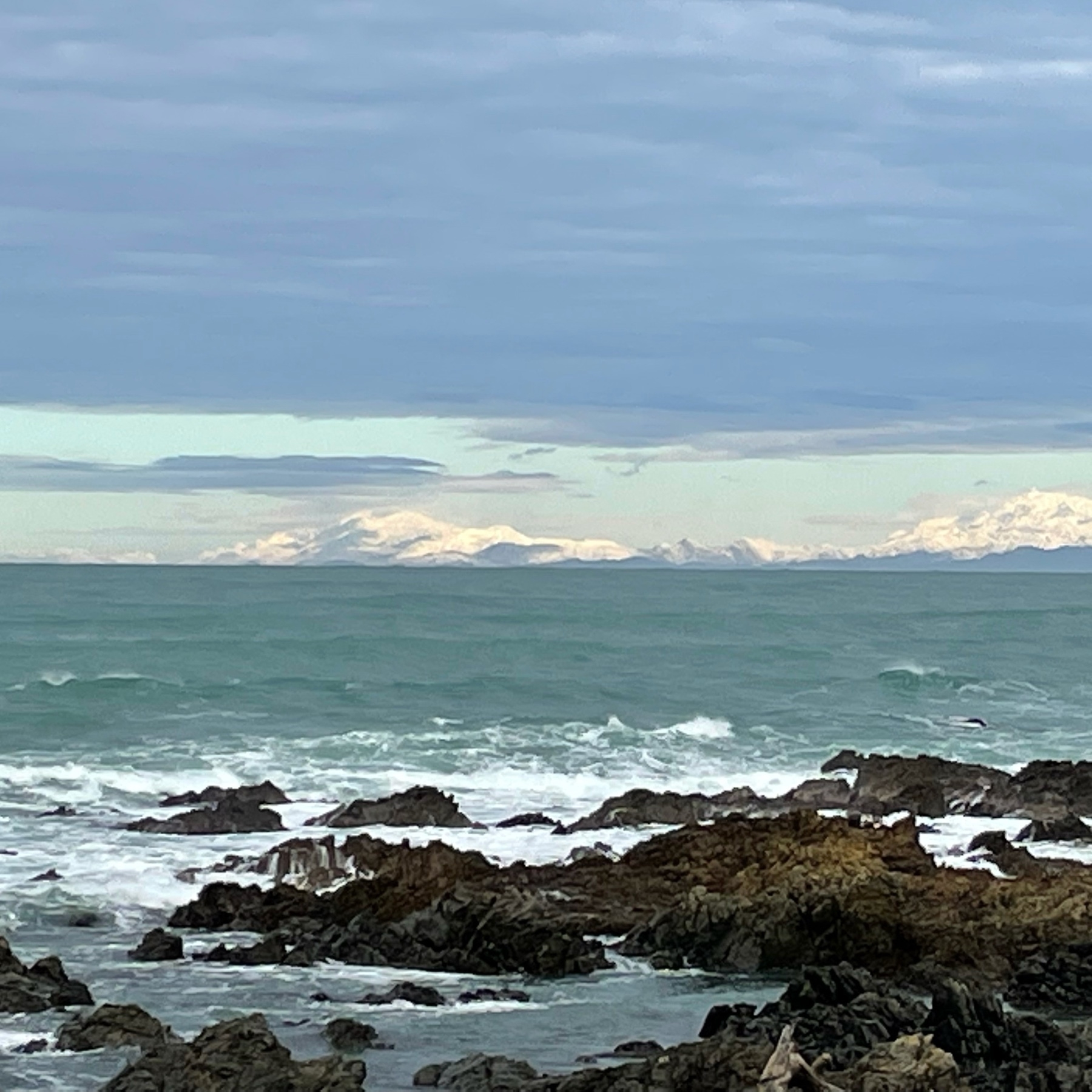A photo of the topnof the South Island, from the Wellington south coast in the North Island. the Mountains and lowlands are ubder a blanket of snow. 