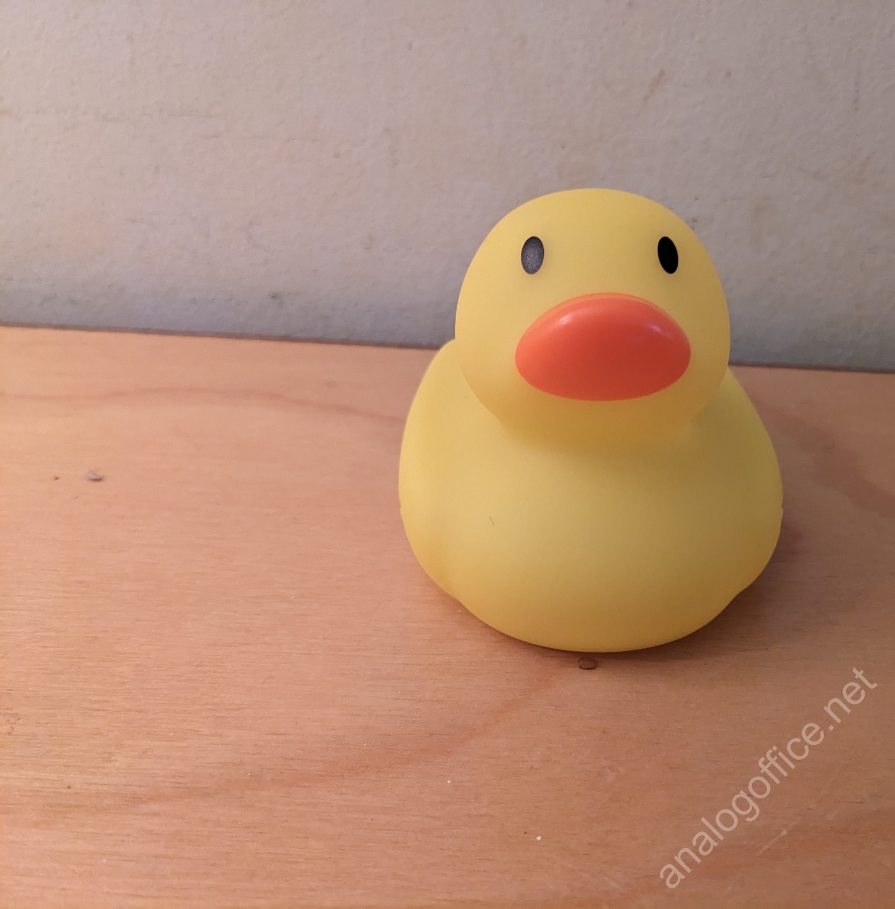 small rubber duck bath toy placed on a shelf
