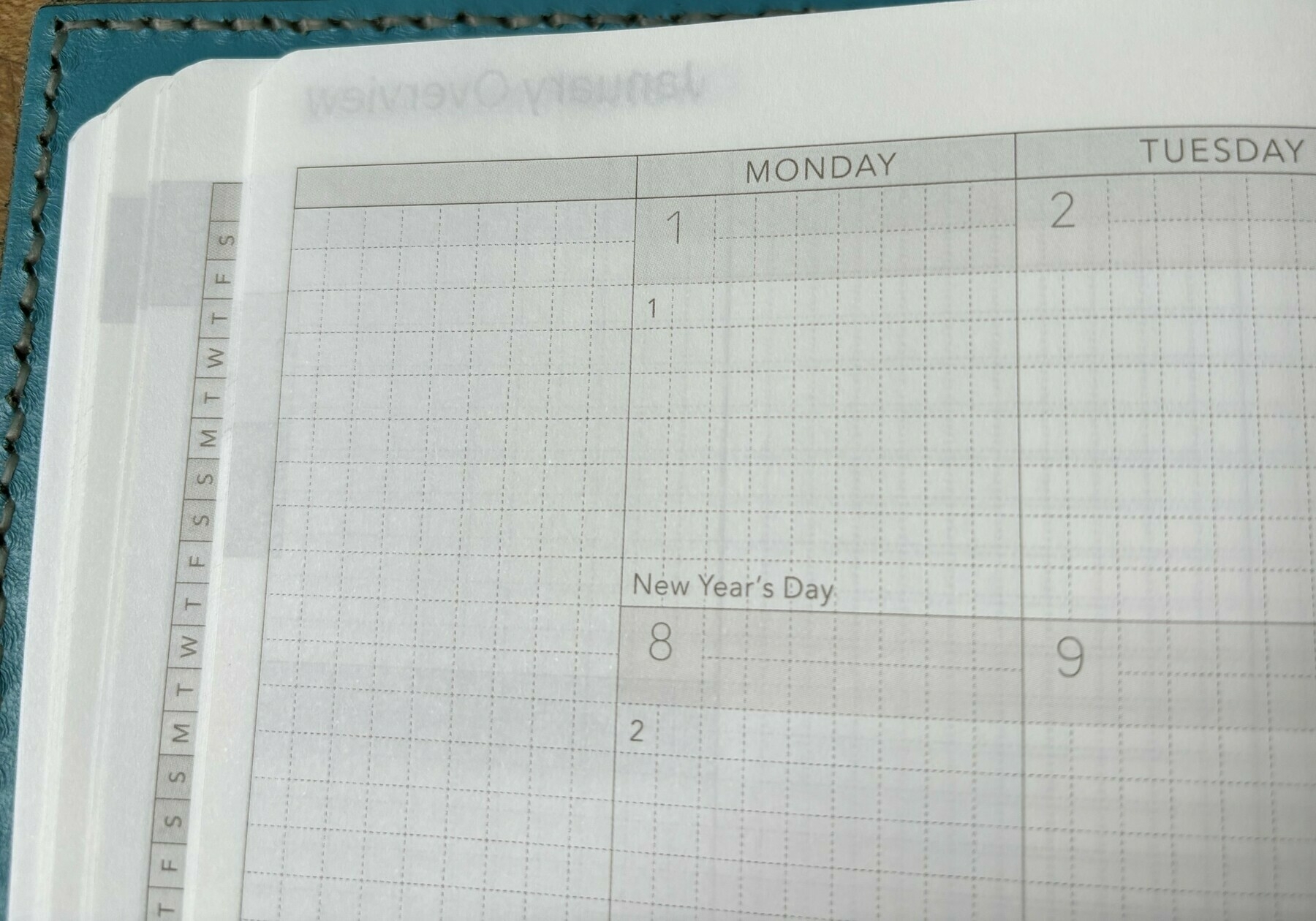 paper planner opened to blank January 2024 calendar page
