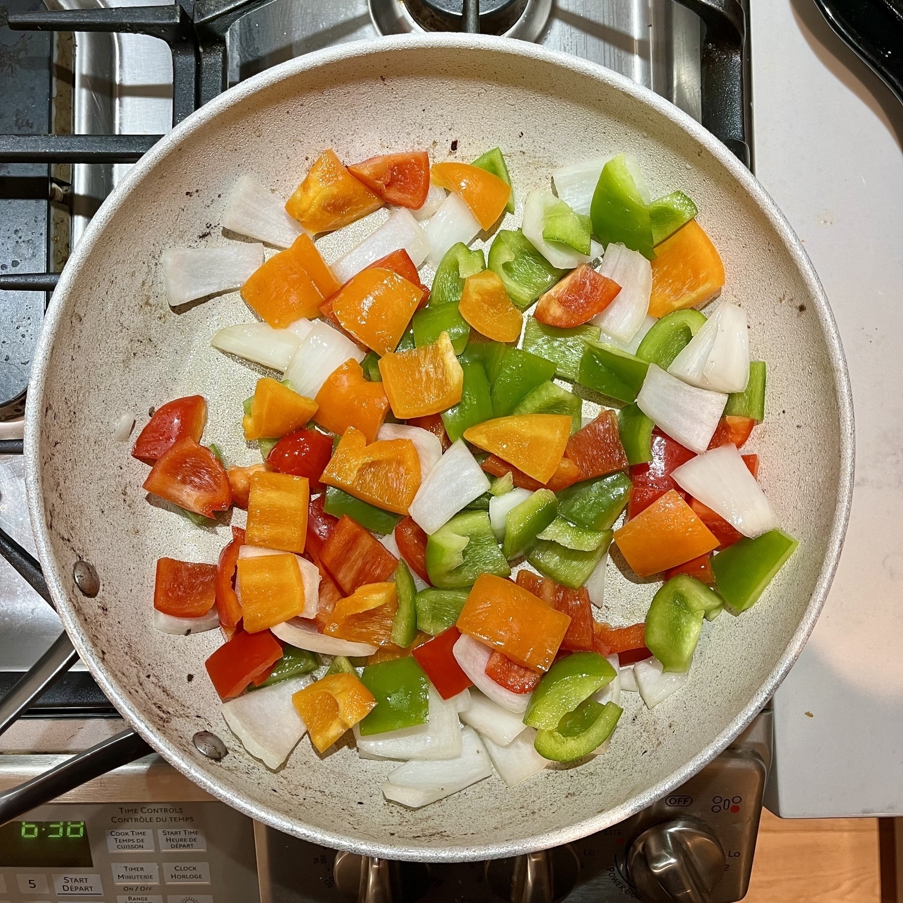 Vegetables in a frying pan, including orange peppers