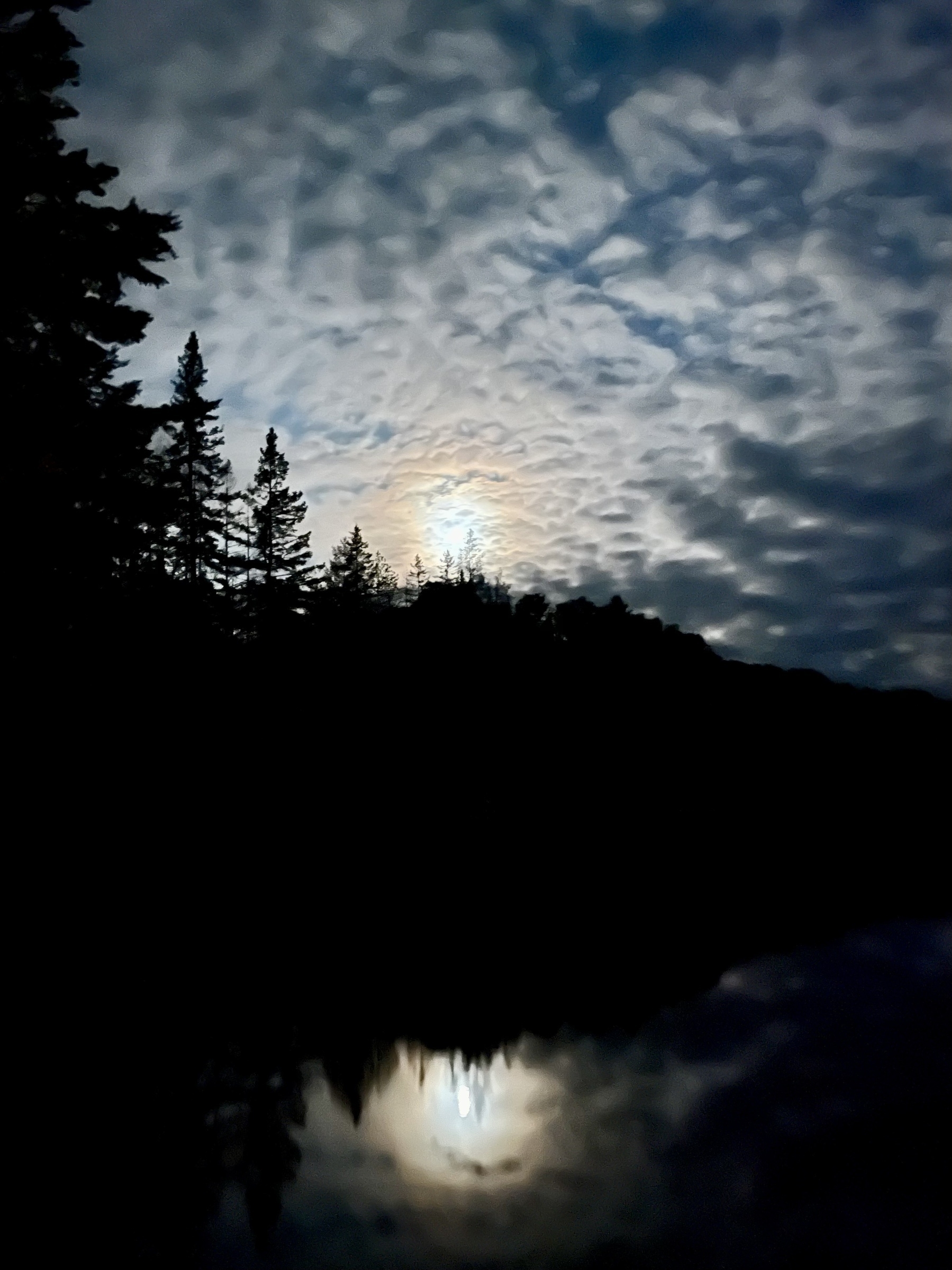 Moon in clouds shining over a lake