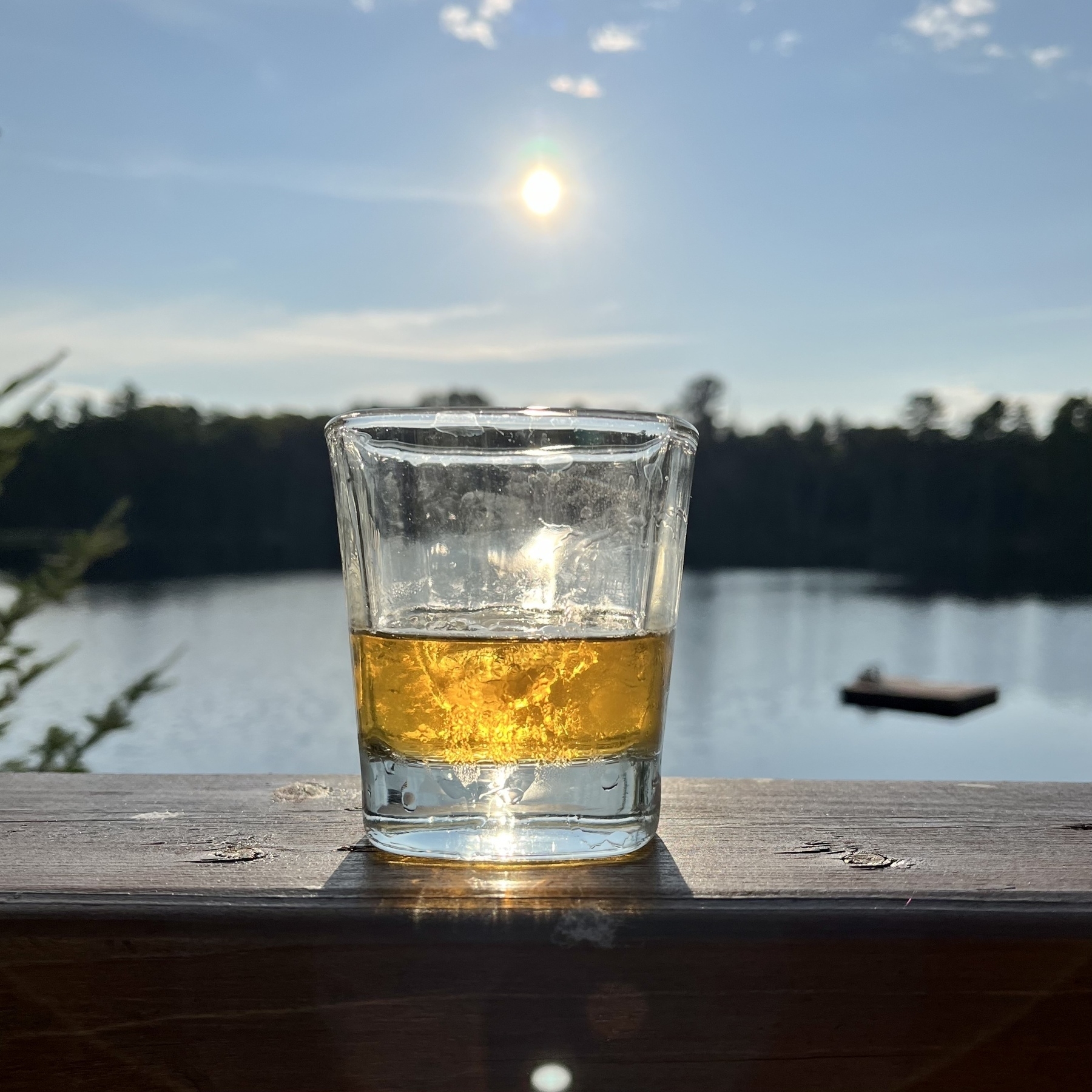 Sun starting to set with a scotch in the foreground 
