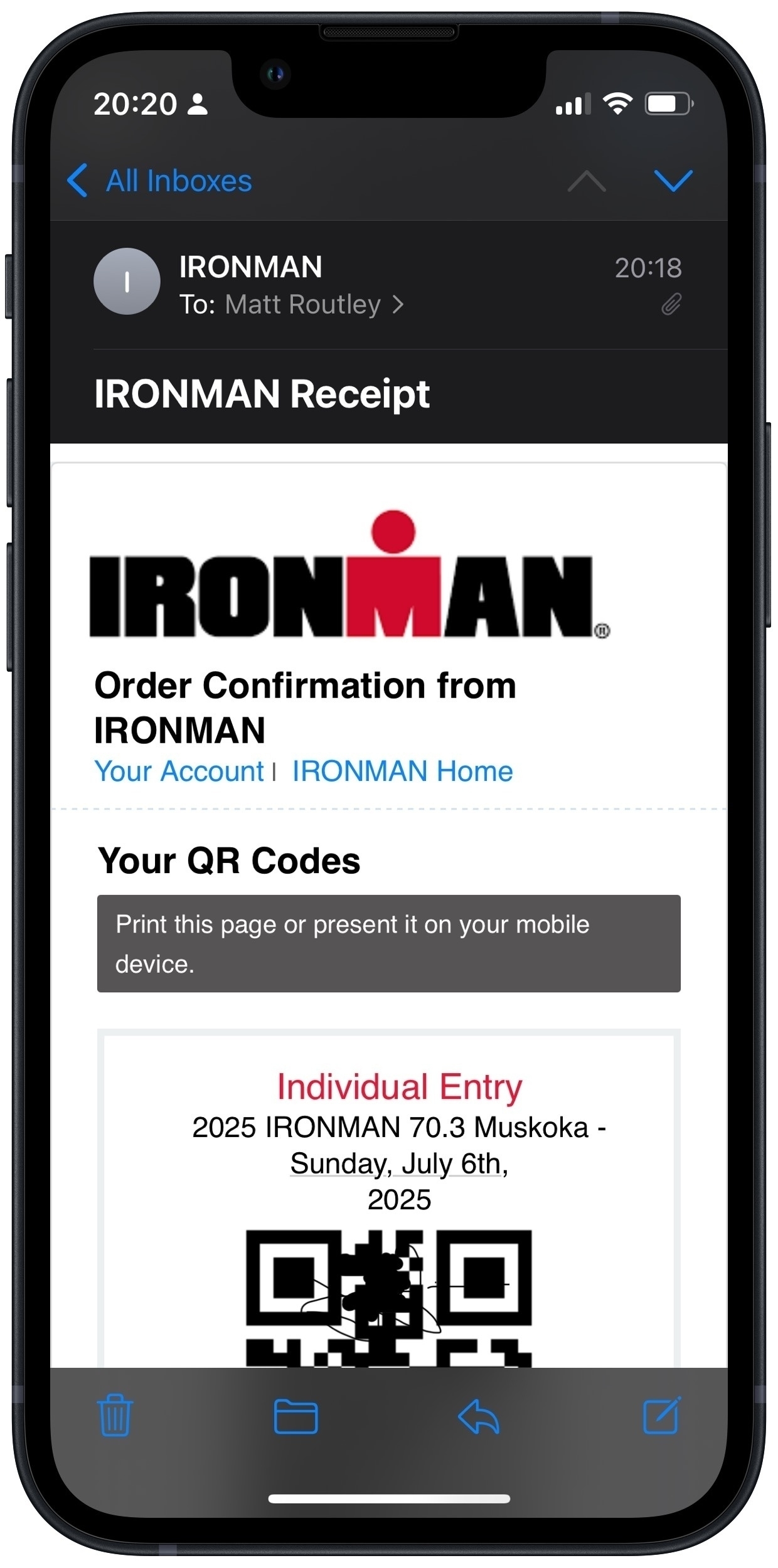 A smartphone screen displays an email receipt for an IRONMAN event registration, including order confirmation details and a QR code.