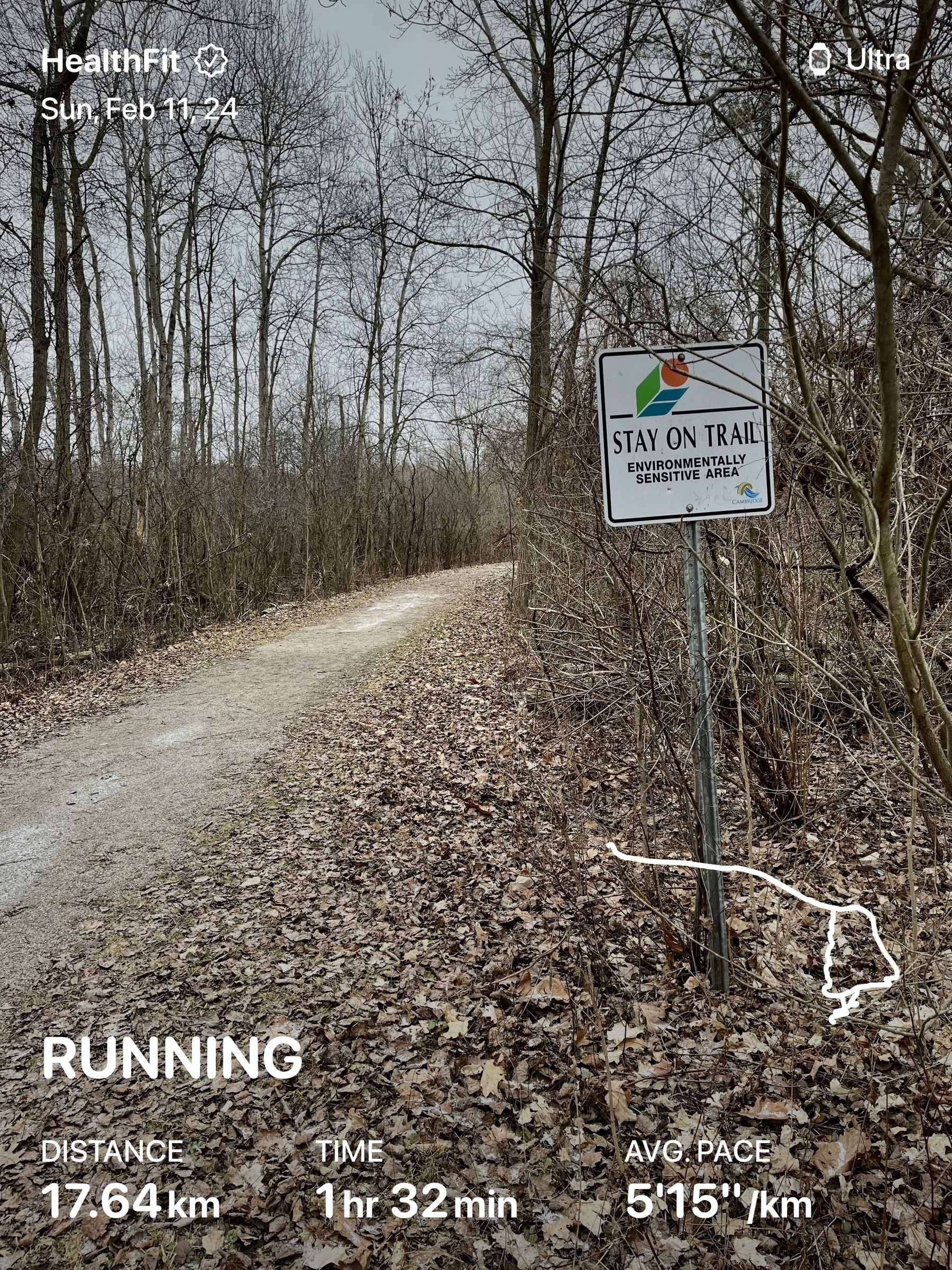 Trail through forest with a sign saying “Stay on trail” to the right. Run statistics overlaid: 17.64 km 1hr32min