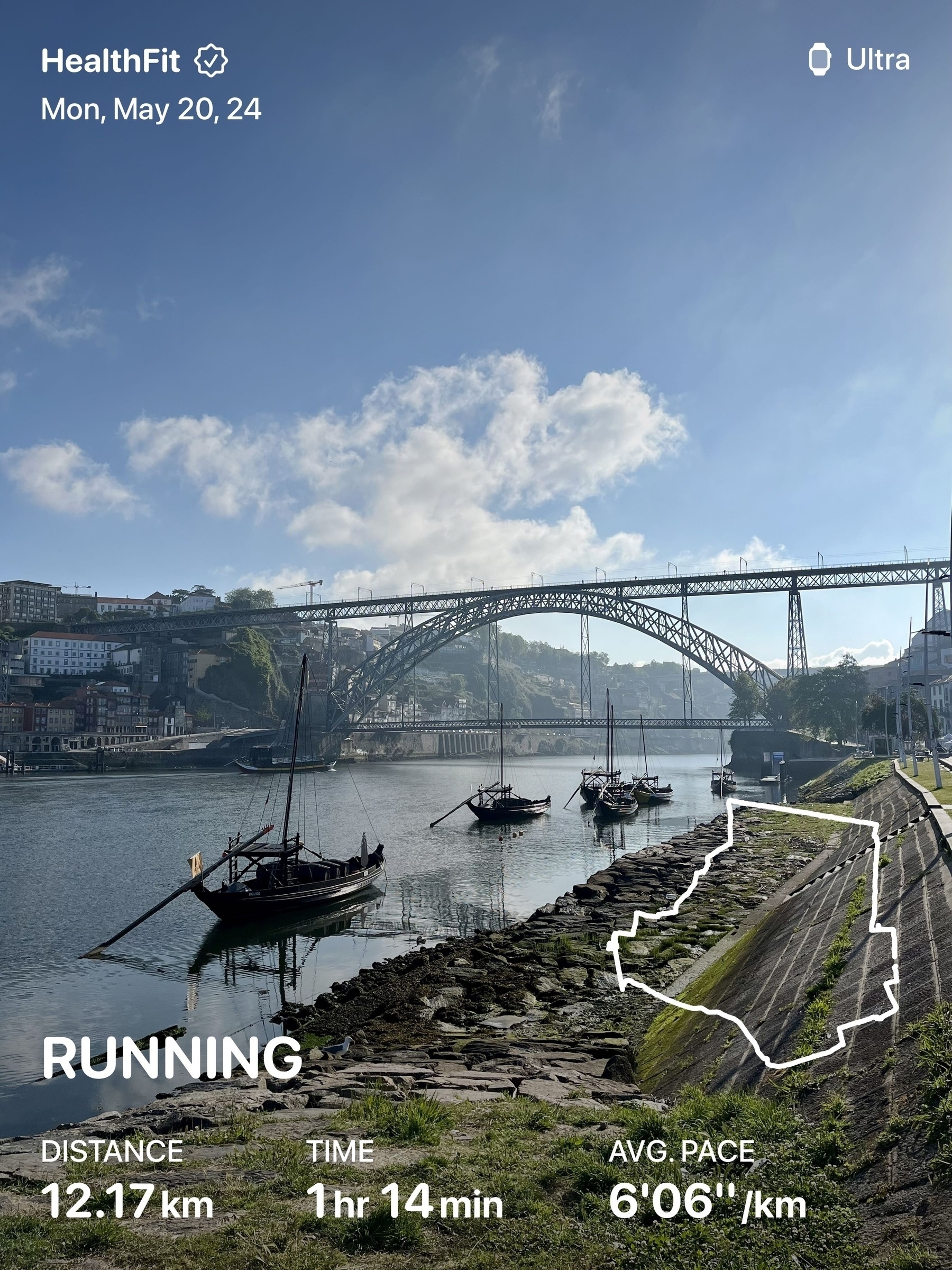 Traditional boats float on calm water with a metal arch bridge in the background, under a partly cloudy sky. Text overlay: HealthFit, Mon, May 20, 24, Ultra, RUNNING, DISTANCE 12.17 km, TIME 1hr 14min, AVG PACE 6:06/km.