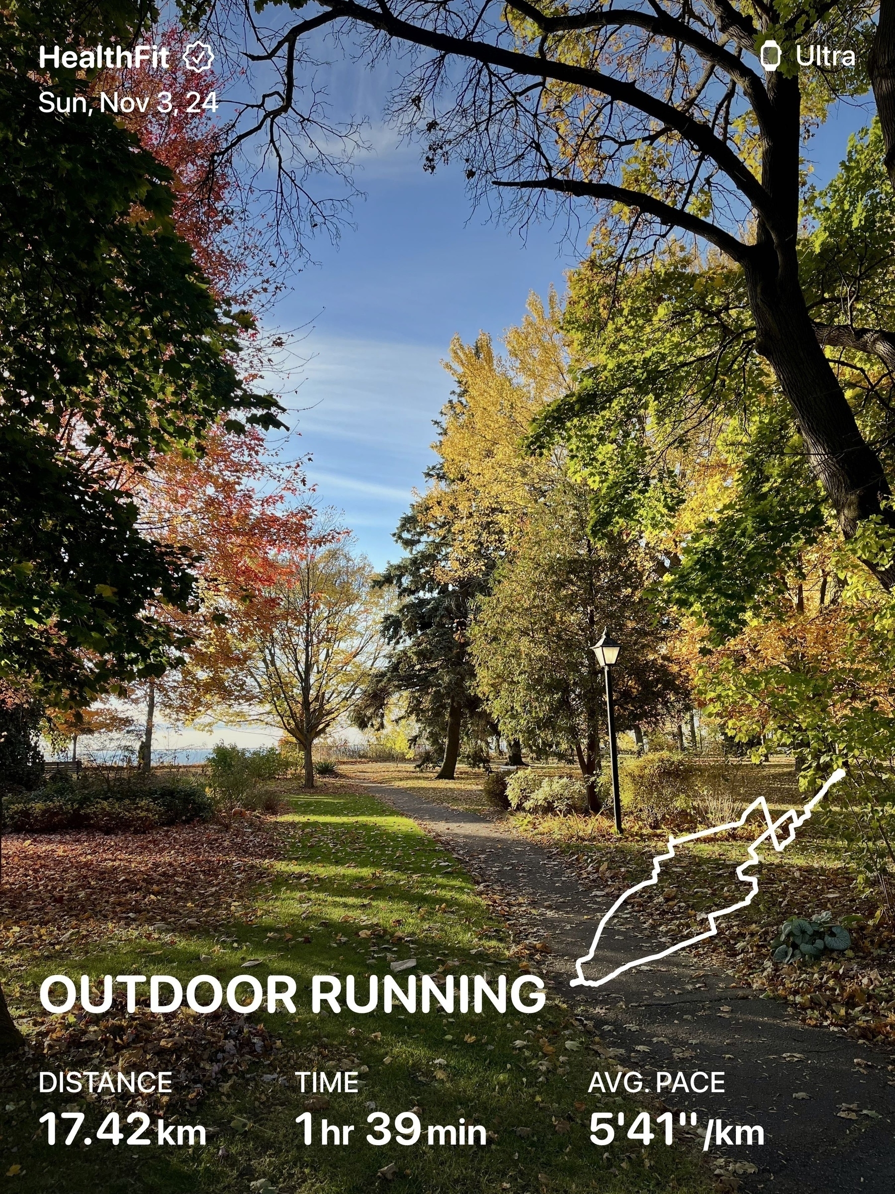 A picturesque park setting with autumn trees and a running path is displayed alongside fitness tracking stats for an outdoor run.