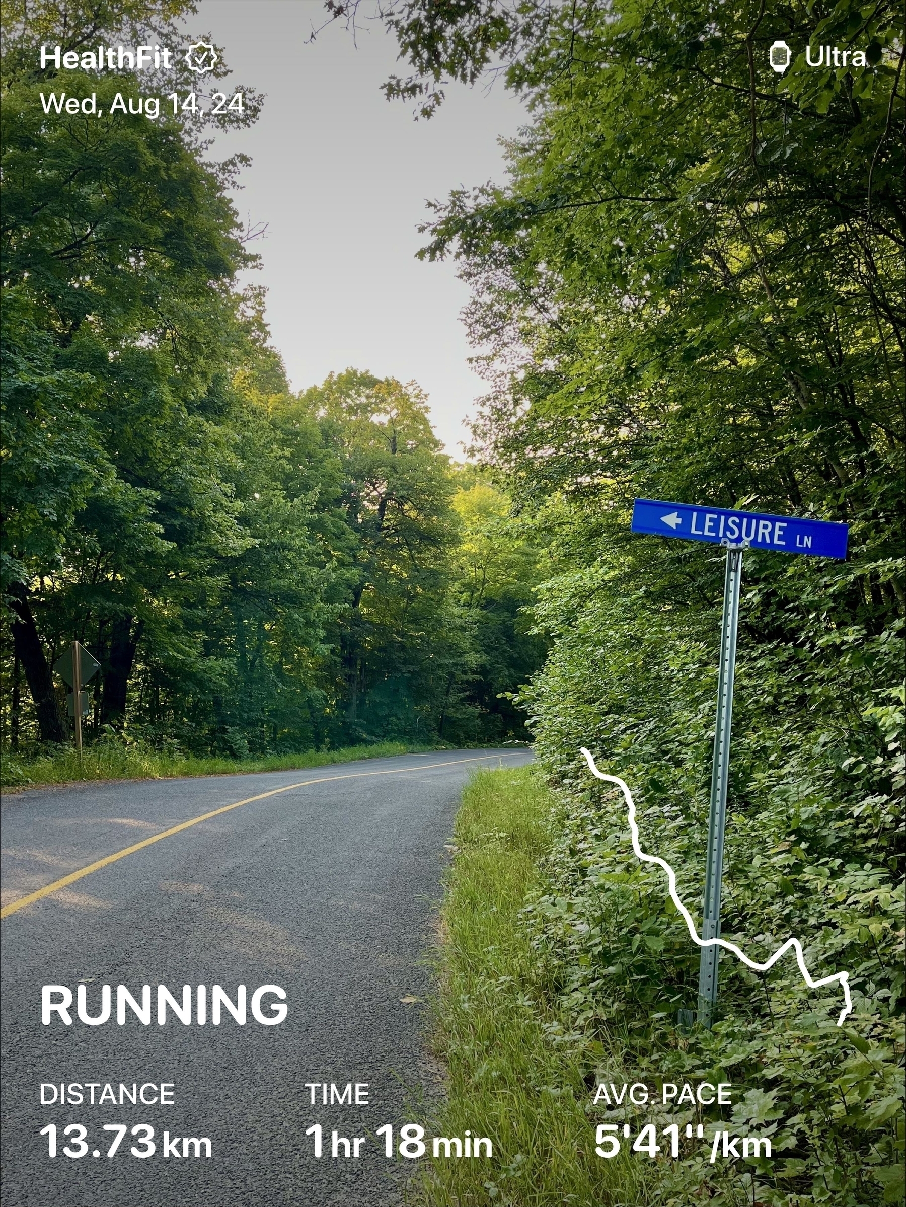 A running app screenshot shows a distance of 13.73 km covered at an average pace of 5'41/km, with a road and a LEISURE Ln sign in the background amidst lush greenery.