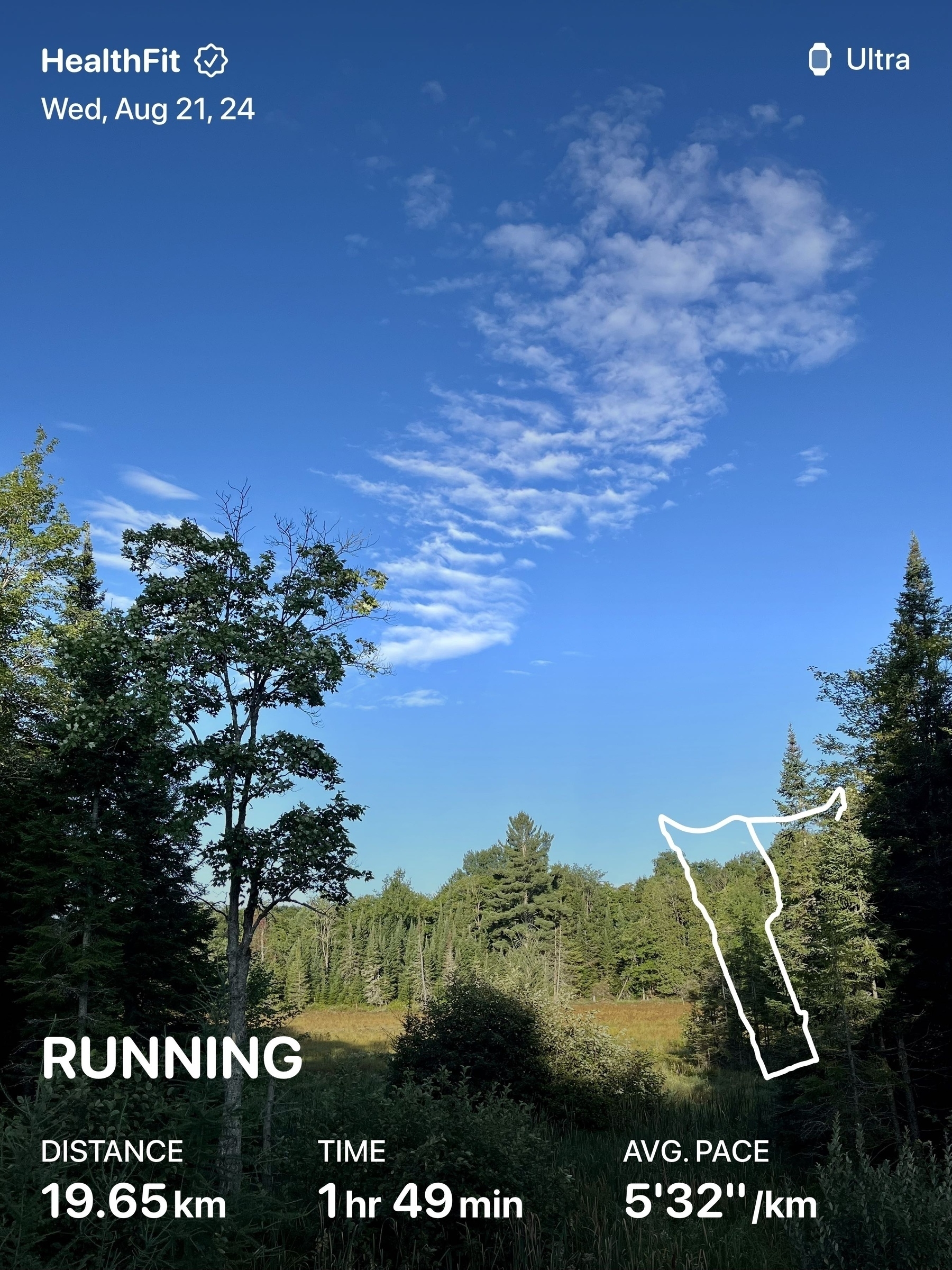 A workout tracking screen displaying a running distance of 19.65 km, time of 1 hour 49 minutes, and an average pace of 5'32"/km, with a scenic background of trees and a partially cloudy sky.