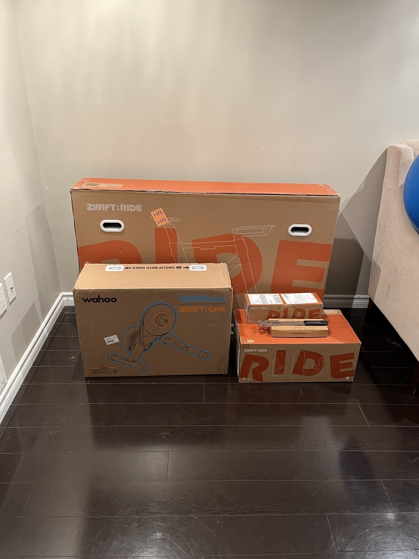 Five boxes of various sizes are stacked in a corner, featuring branding for Zwift and Wahoo.