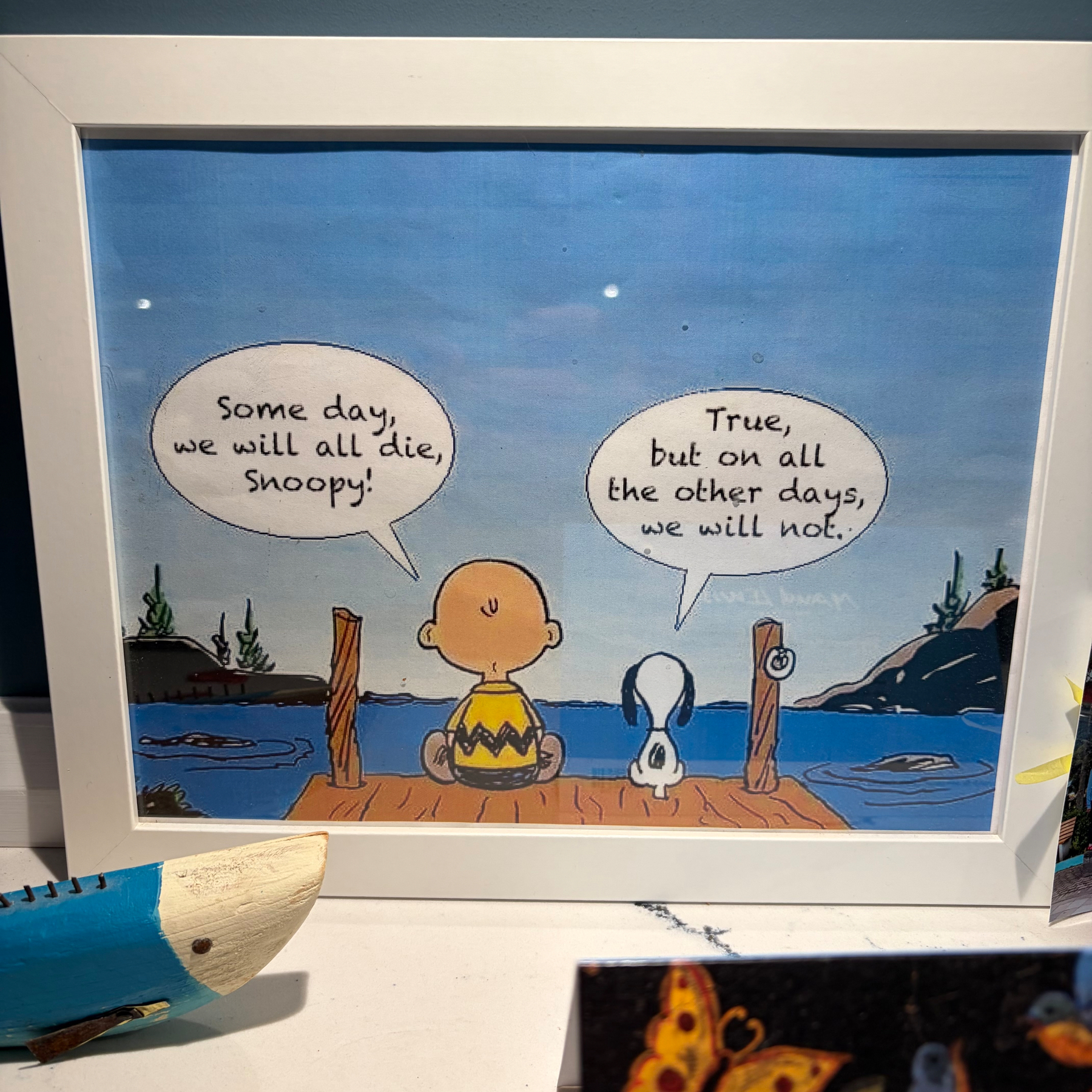Charlie Brown and Snoopy sit on a dock by the water, having a reflective conversation about life and death.