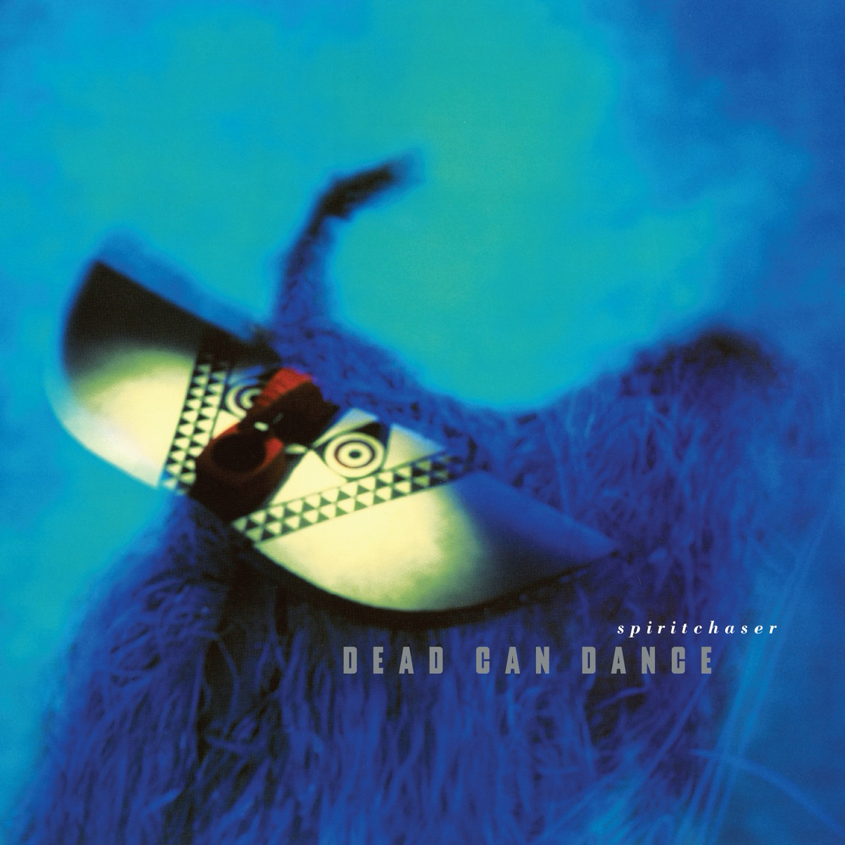 A tribal mask is set against a vibrant blue background with the words Dead Can Dance - Spiritchaser visible.