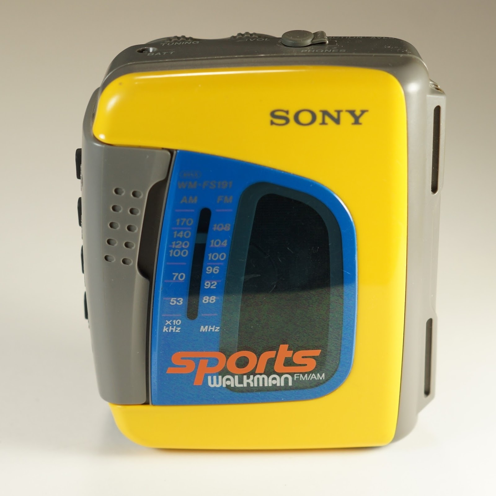 Auto-generated description: A yellow and gray Sony Sports Walkman is shown, featuring an FM/AM radio tuner.
