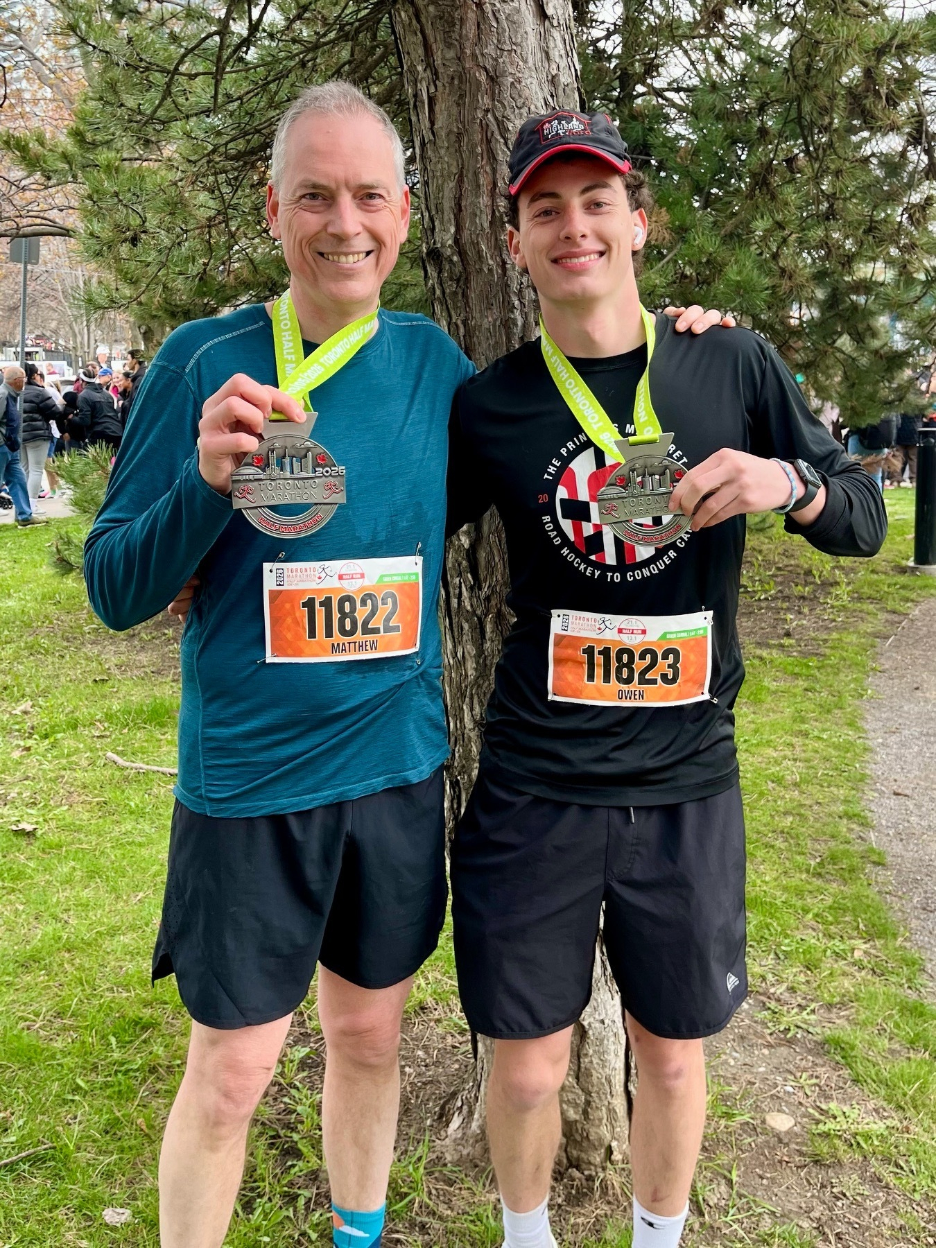 My son and I standing side by side and holding up our finisher medals
