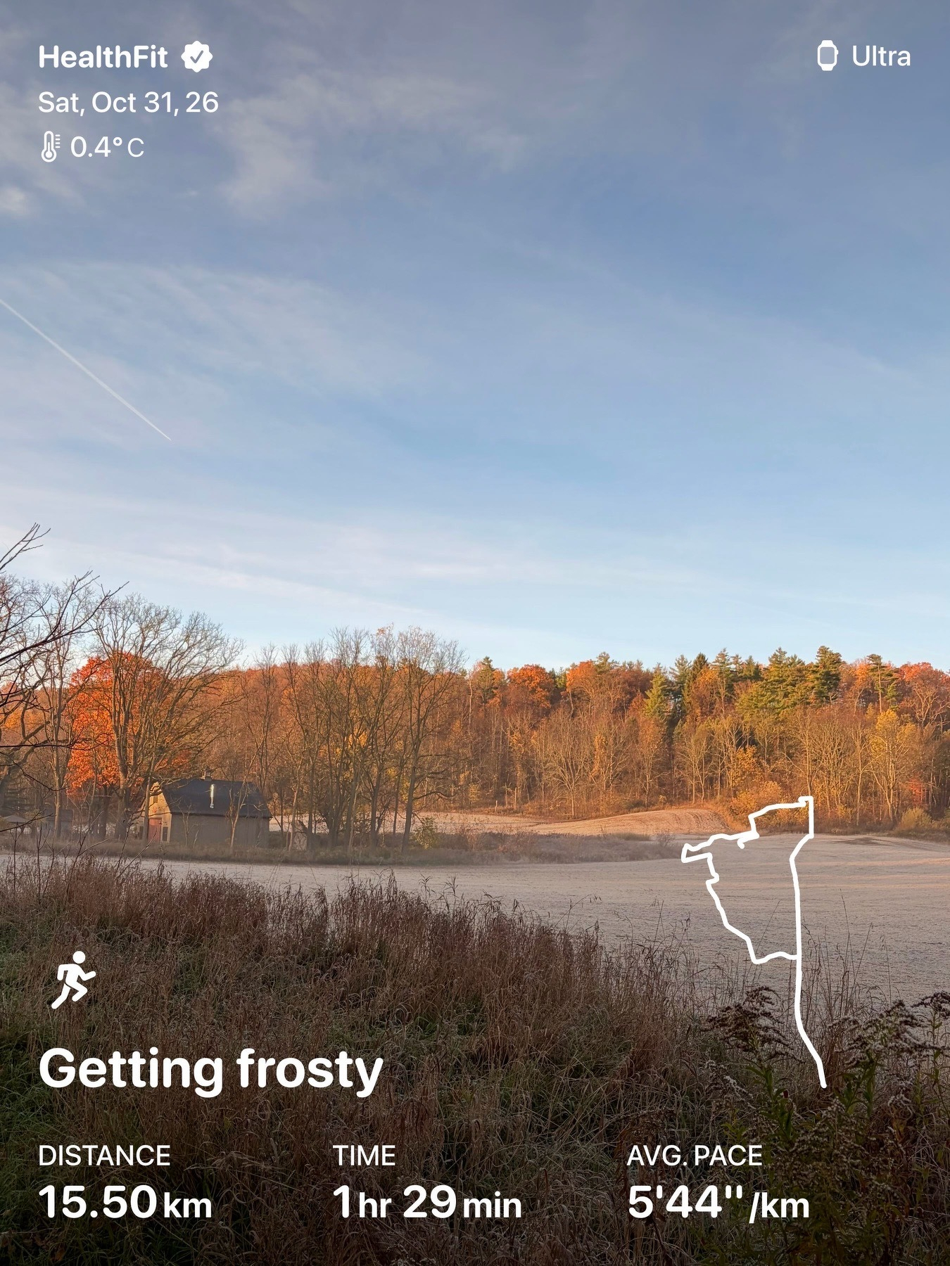 A person running along a dirt path next to a field with autumn trees, under a partly cloudy sky, with a map outline of a running route and fitness data overlaid.