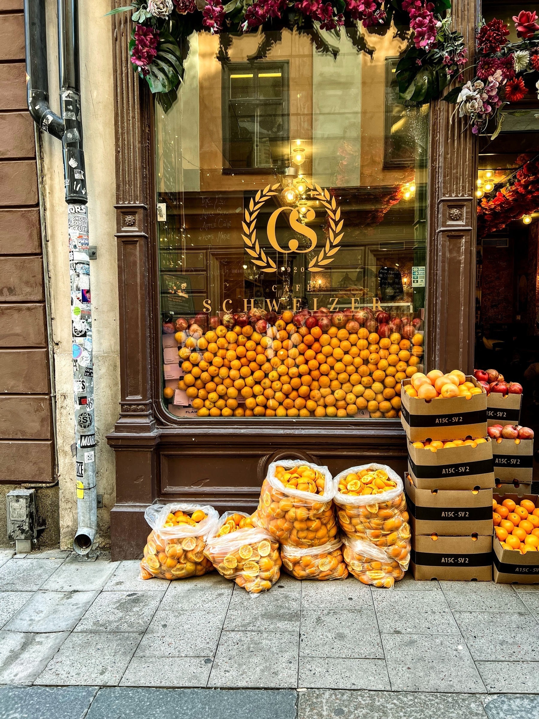 storefront in Stockholm with a window full of oranges, and bags and crates of oranges stacked outside