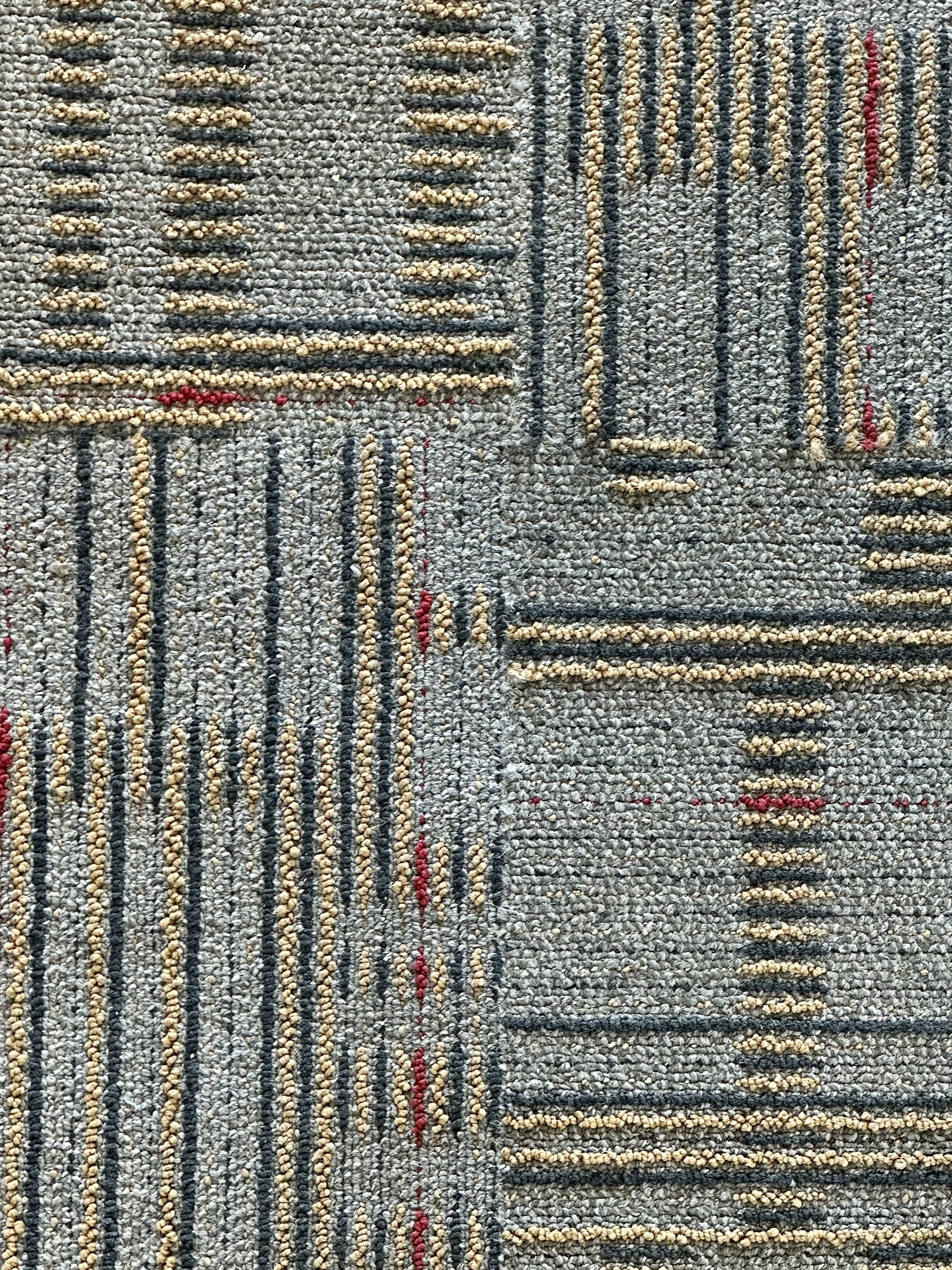 Photo of a dull-gray carpet with an abstract linear pattern.