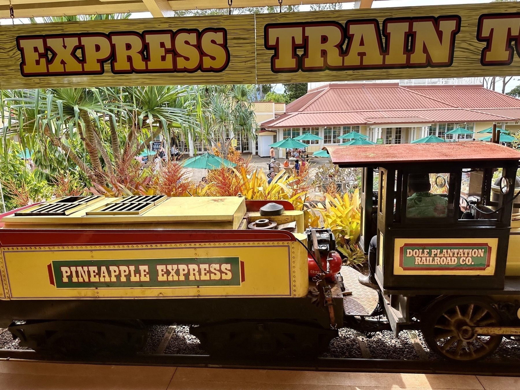Small, bright yellow train labeled “Pineapple Express”