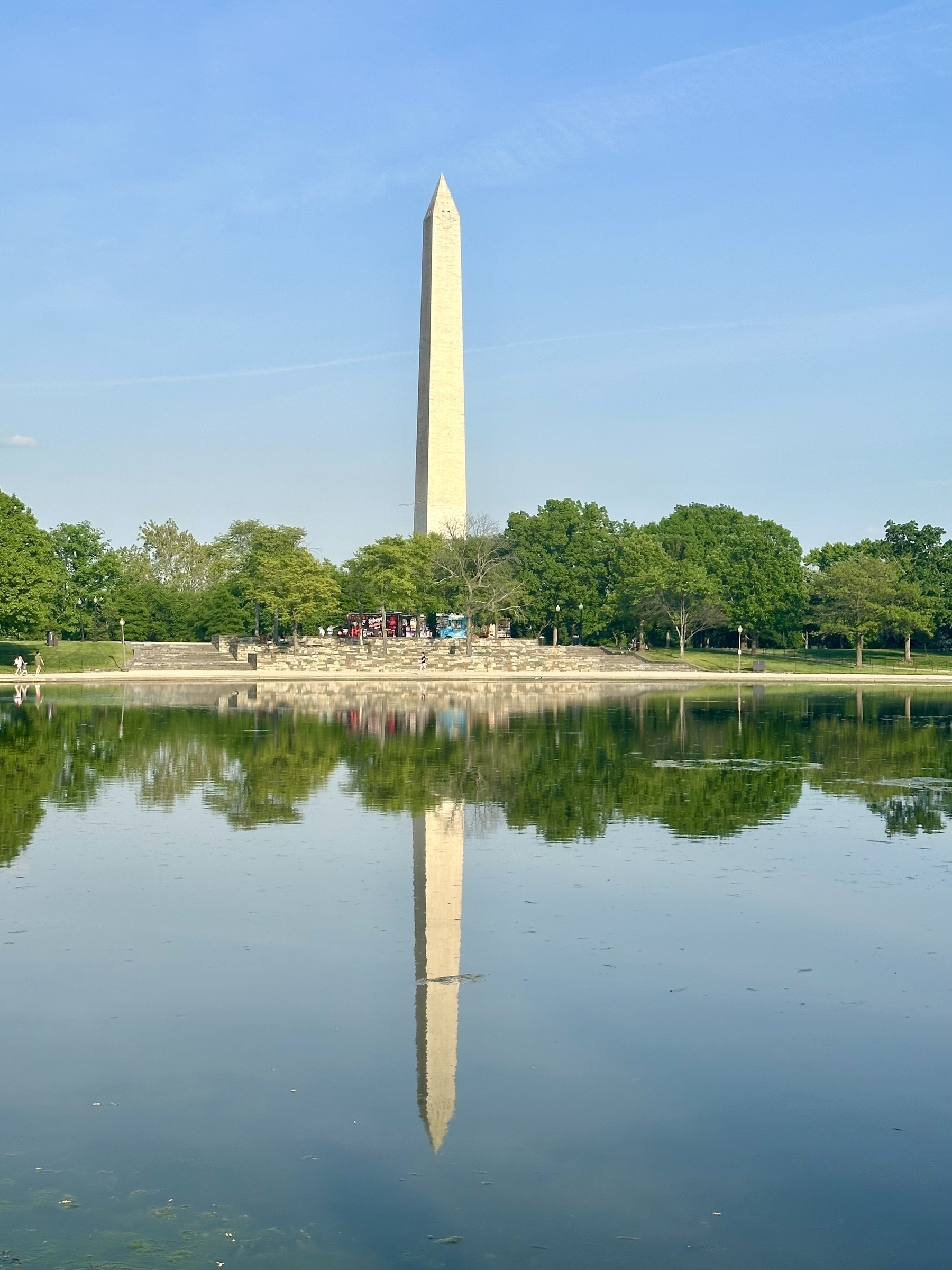 The Washington monument reflect in water on a clear sunny day.
