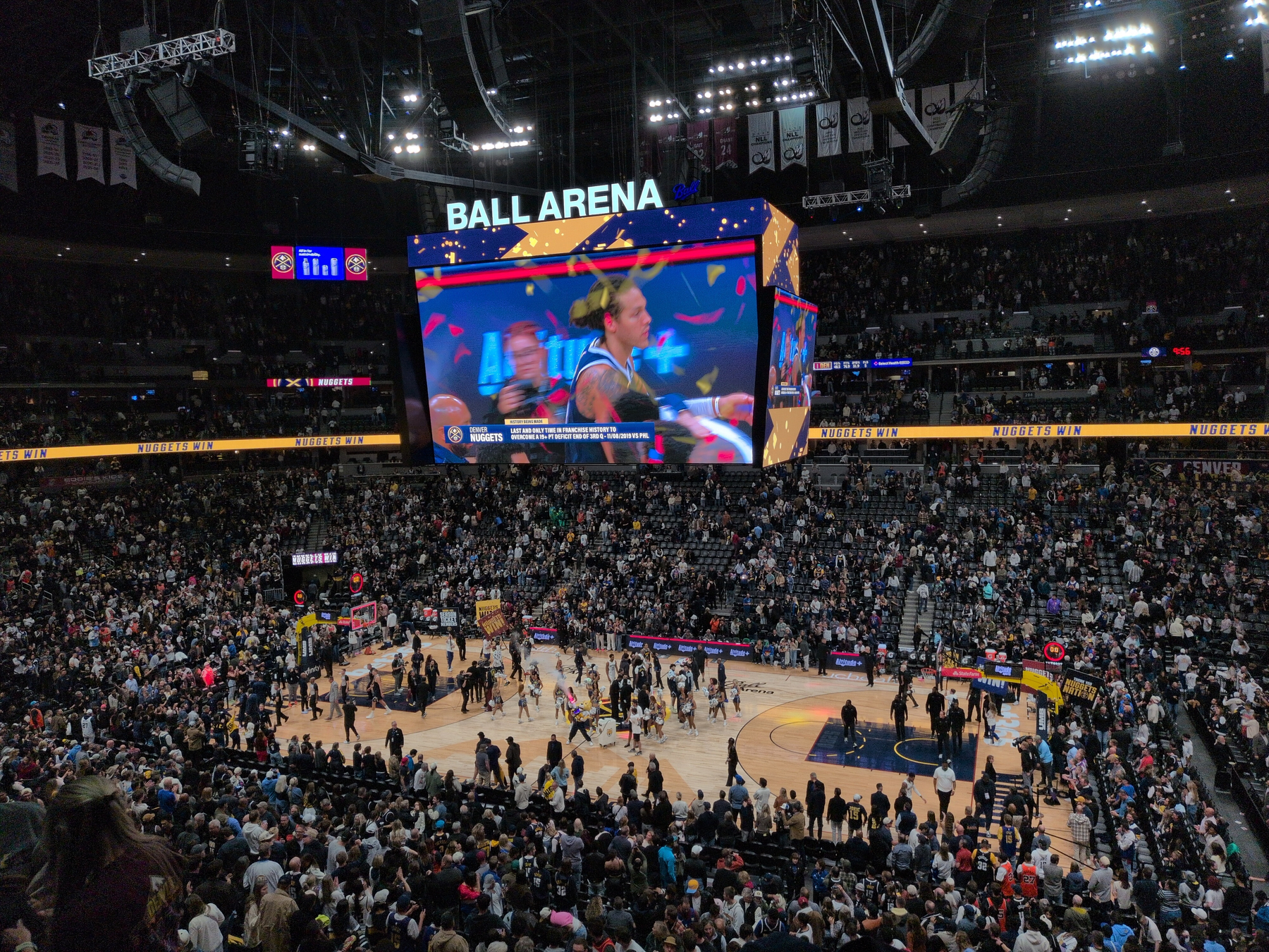 A large crowd is gathered inside Ball Arena watching a basketball event, with Aron Gordon shown on the overhead screen. The Nuggets won in overtime!