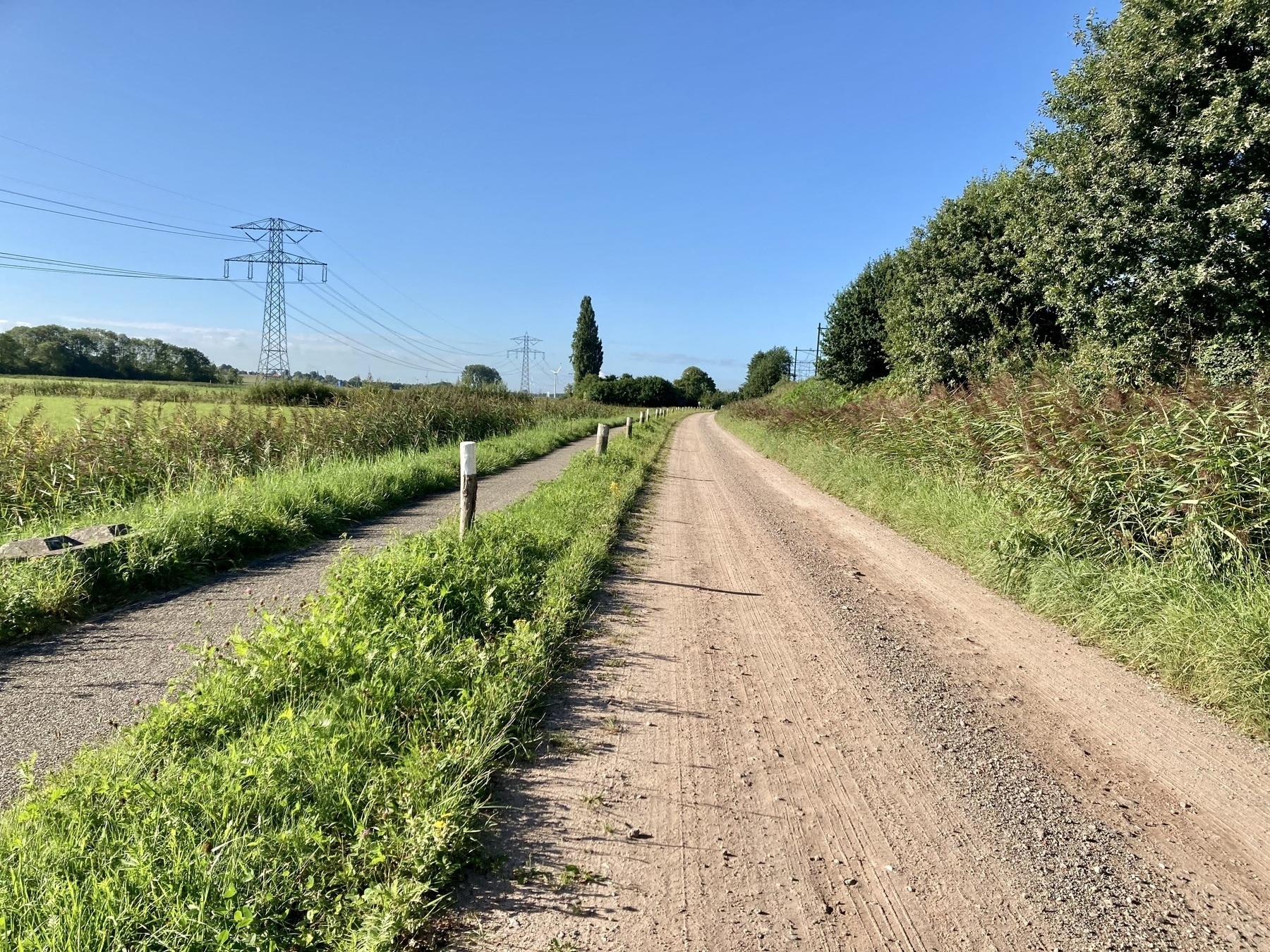 narrow straight dirt road with bike lane alongside
