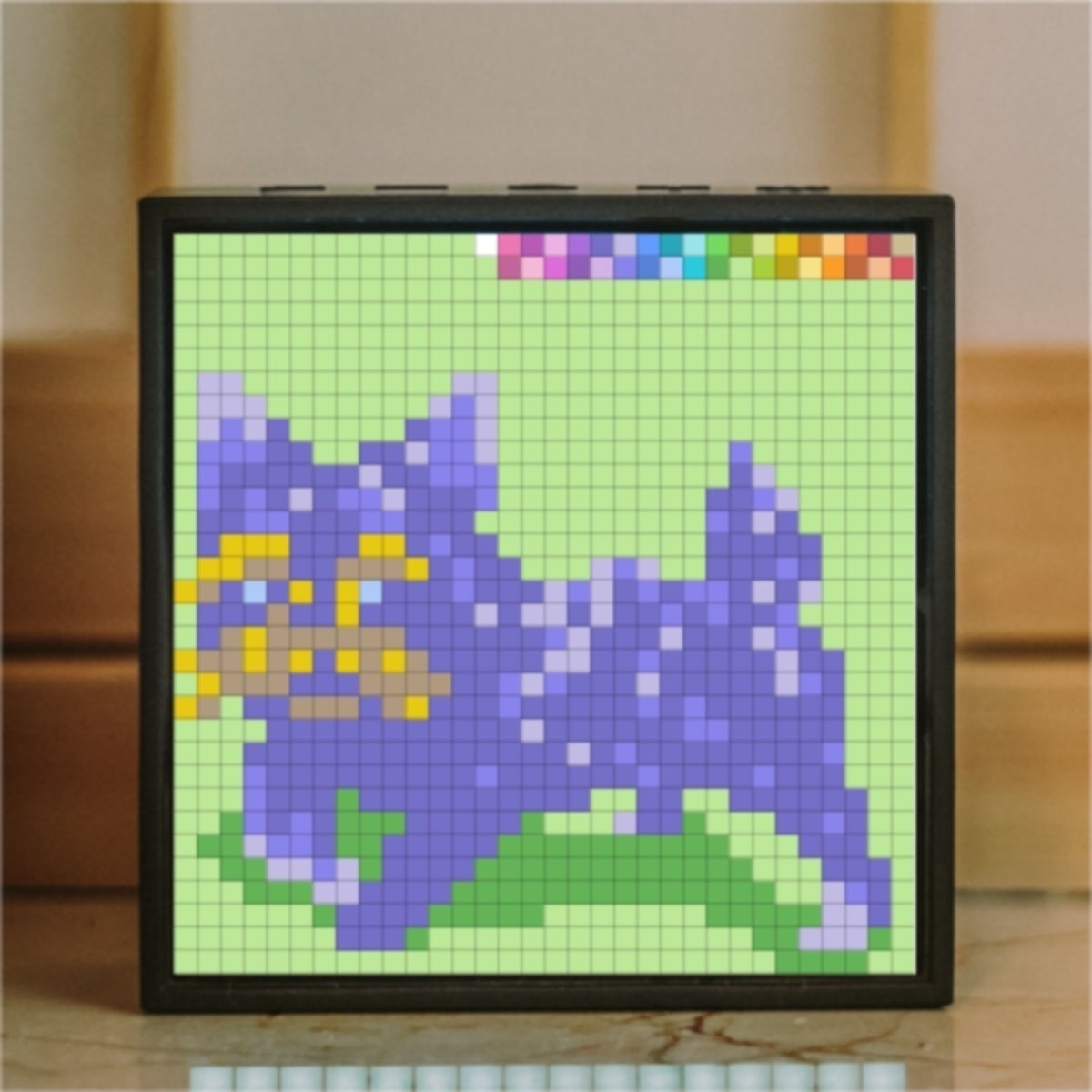 A pixelated dog design with purple colors on a green background is displayed on a digital screen.