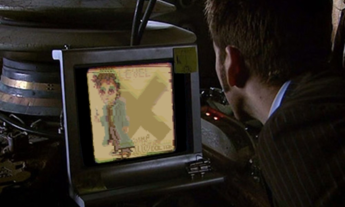 A person in a suit looks at a small monitor displaying a pixelated image of a cartoon character.