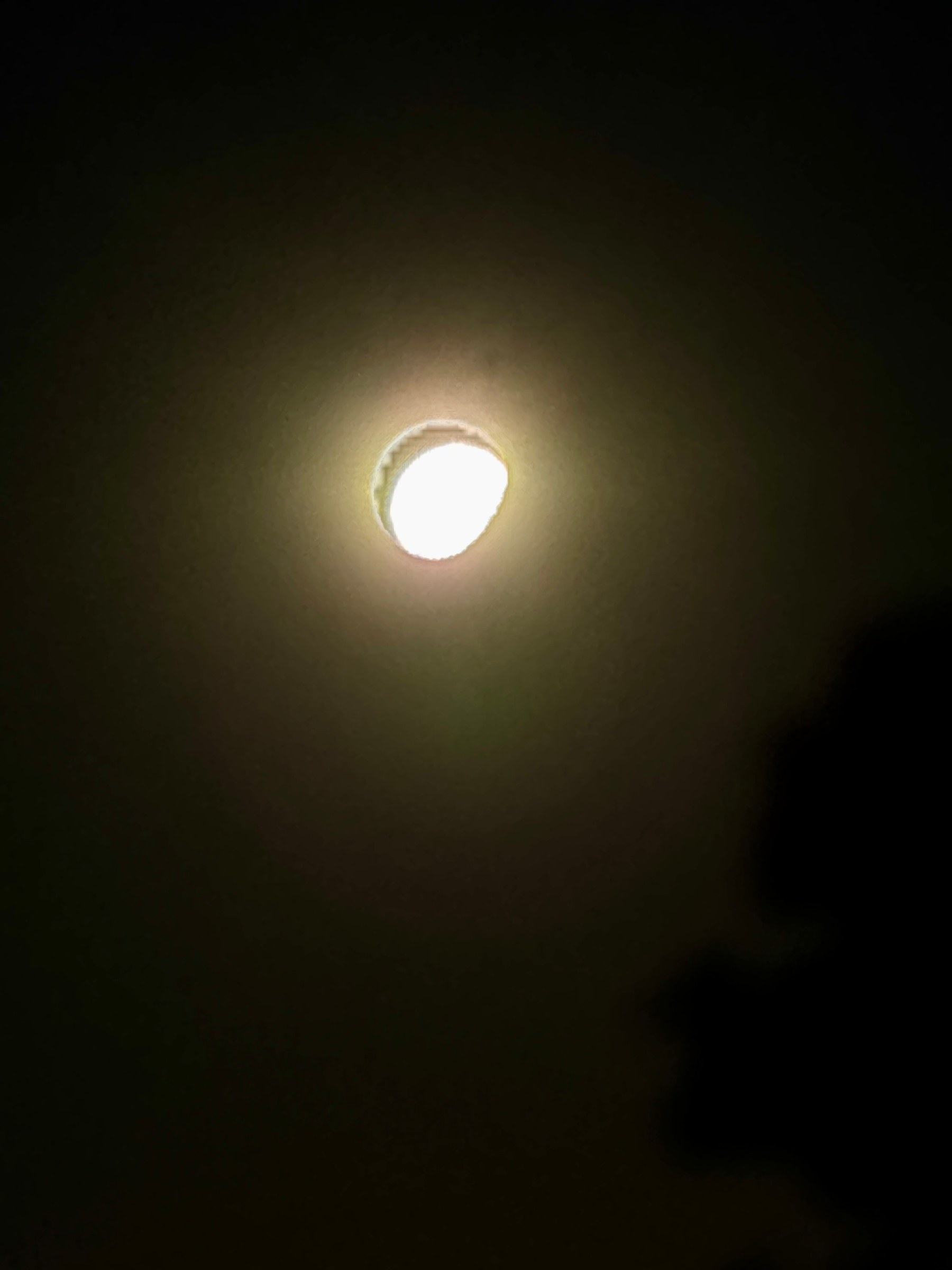 Auto-generated description: A bright, glowing light source surrounded by a dark background with a faint halo of light.