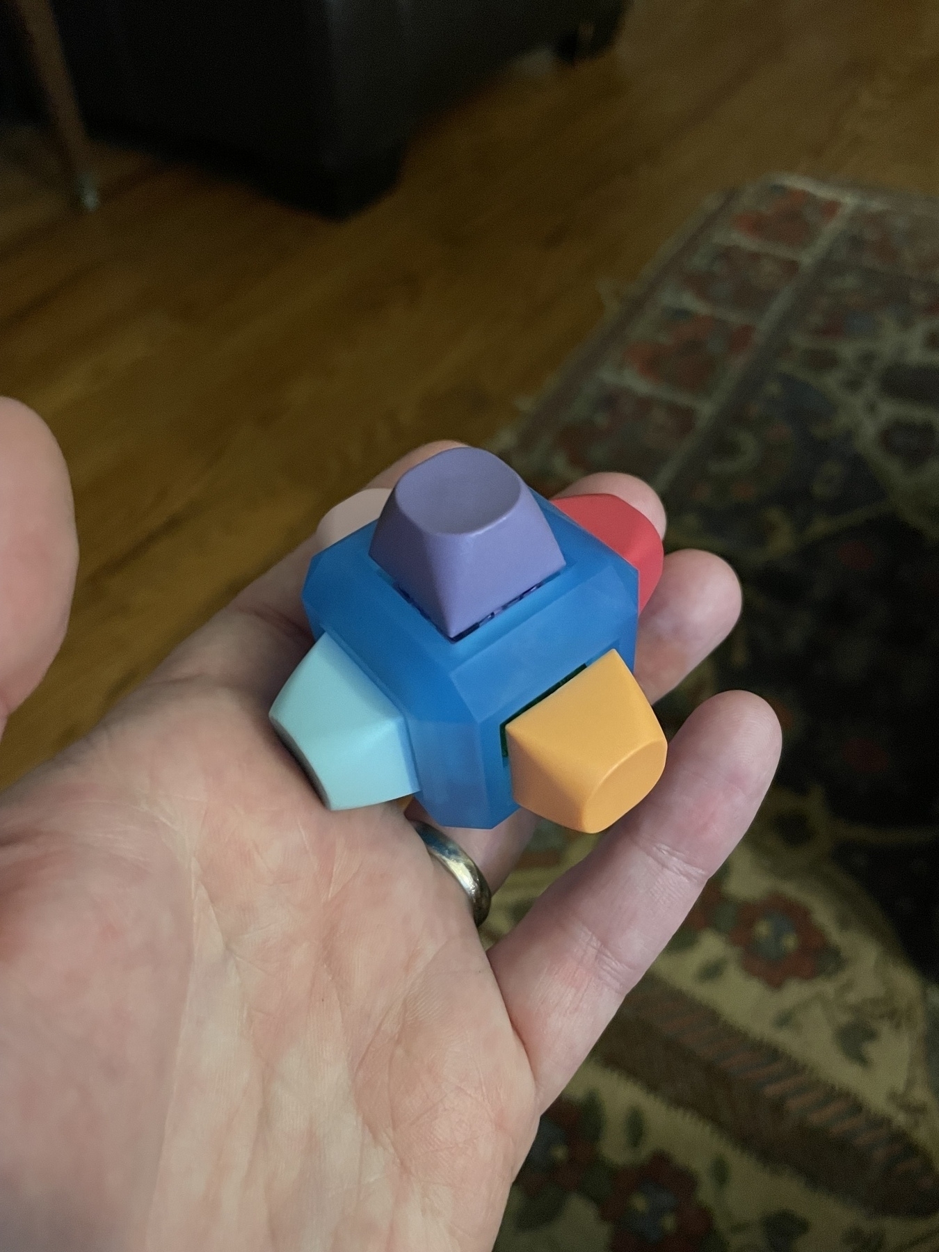 Evan’s left hand holding a cube with a keyboard key on each side.