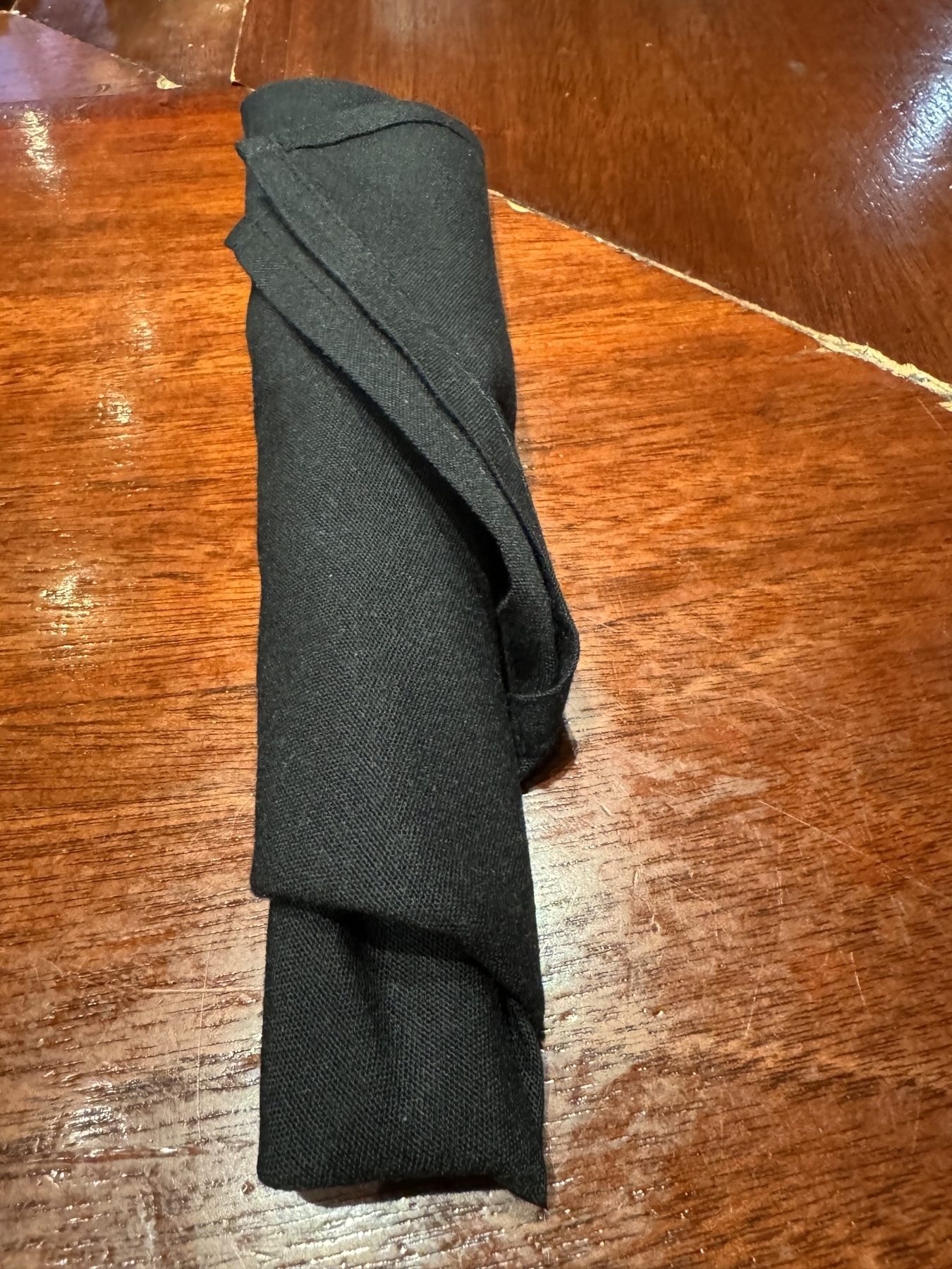 Restaurant utensils in a black napkin 