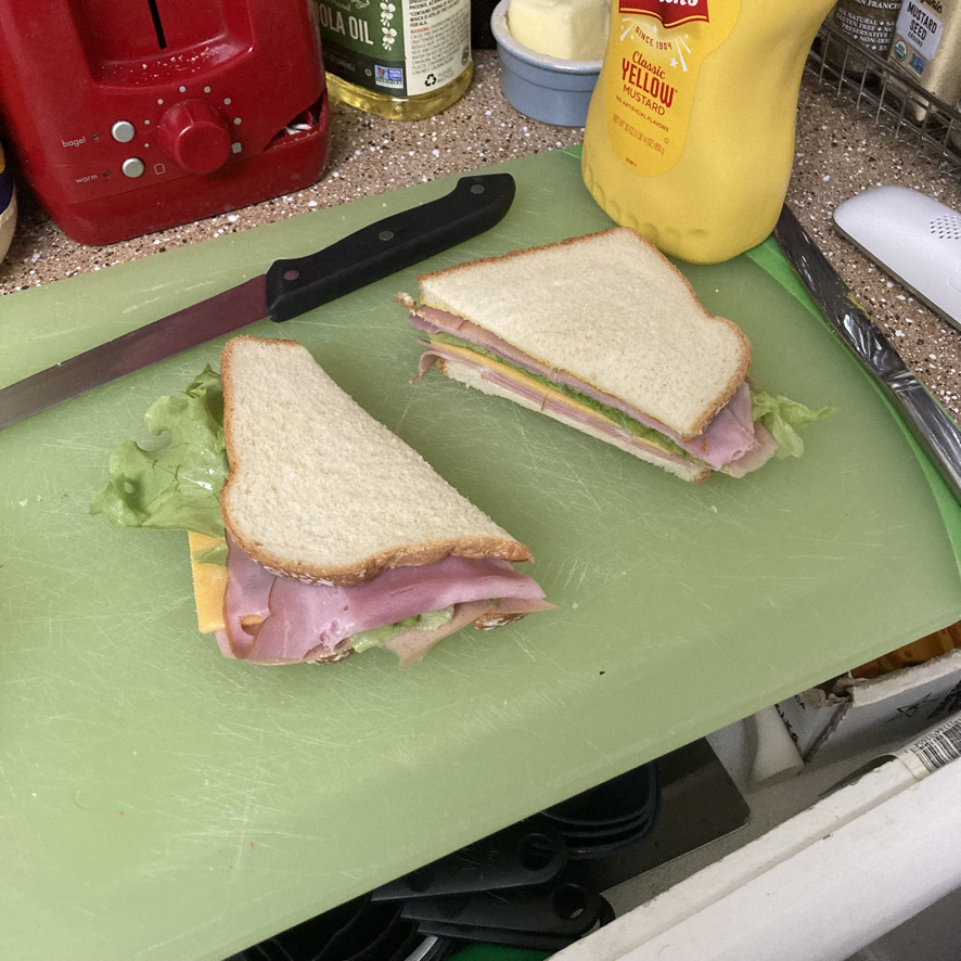 Ham and montedelo sandwich with mustard and mayo.