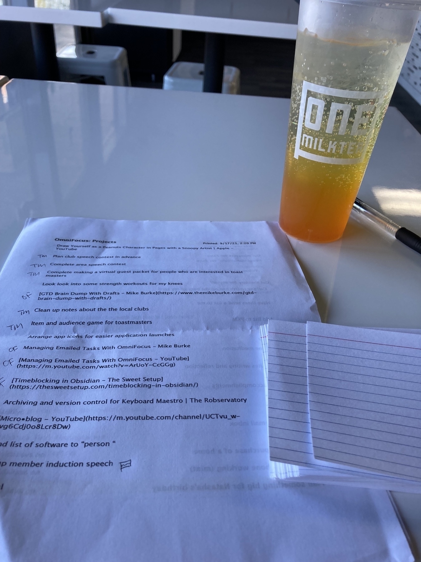 Tasks list next to a orange drink. 