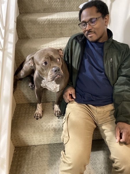 A man and his dog sitting on the stairs