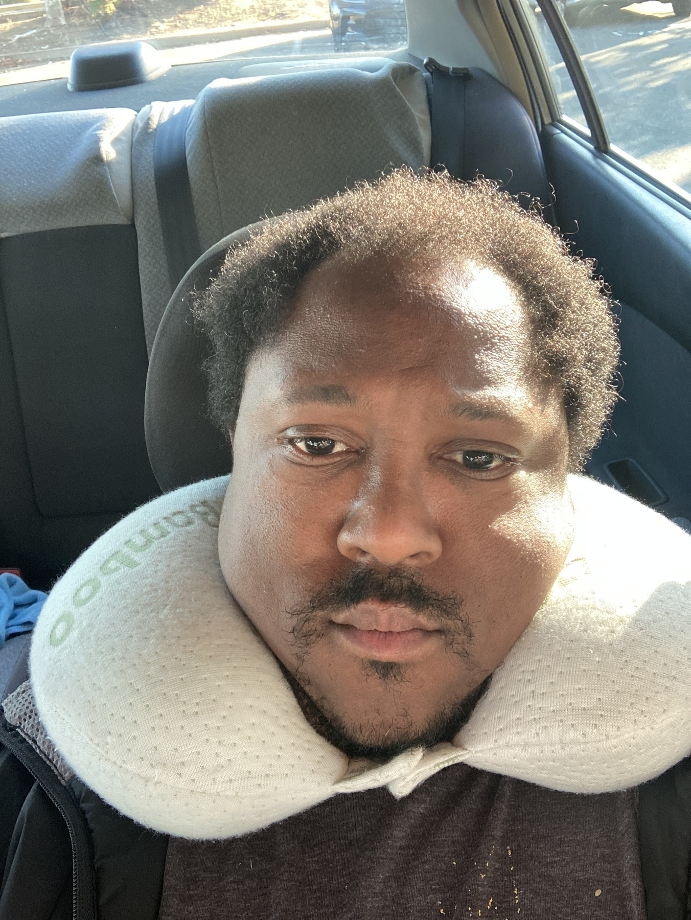 Man wearing a neck pillow. 