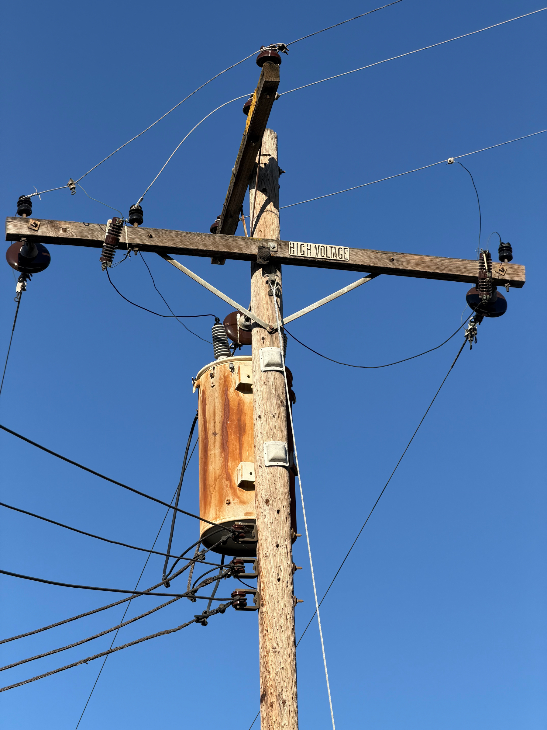 A power line with a rusty transformer. 